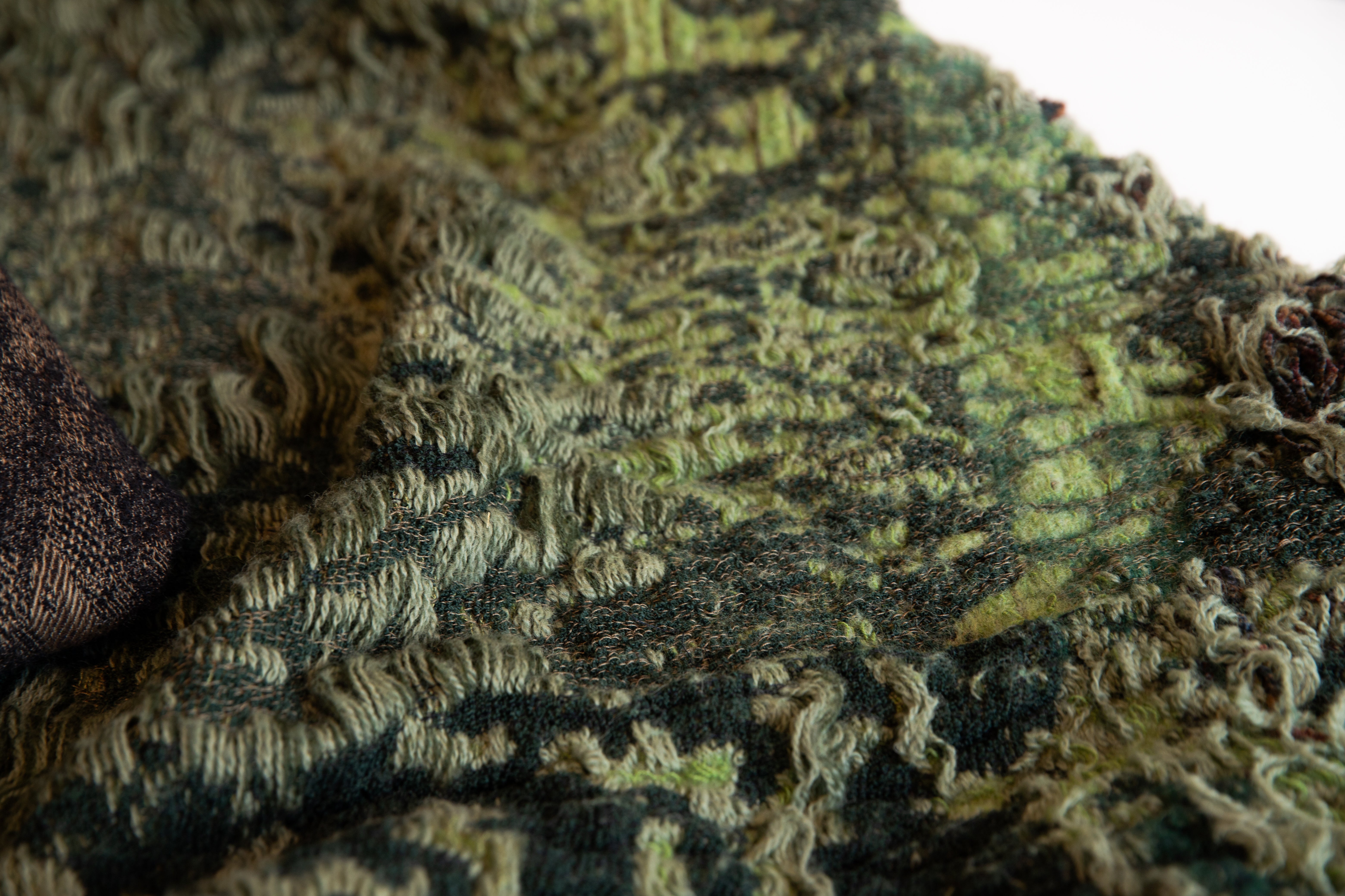 Jacquard woven and hand felted fabric designed and engineered to simulate wild grass as a rug.