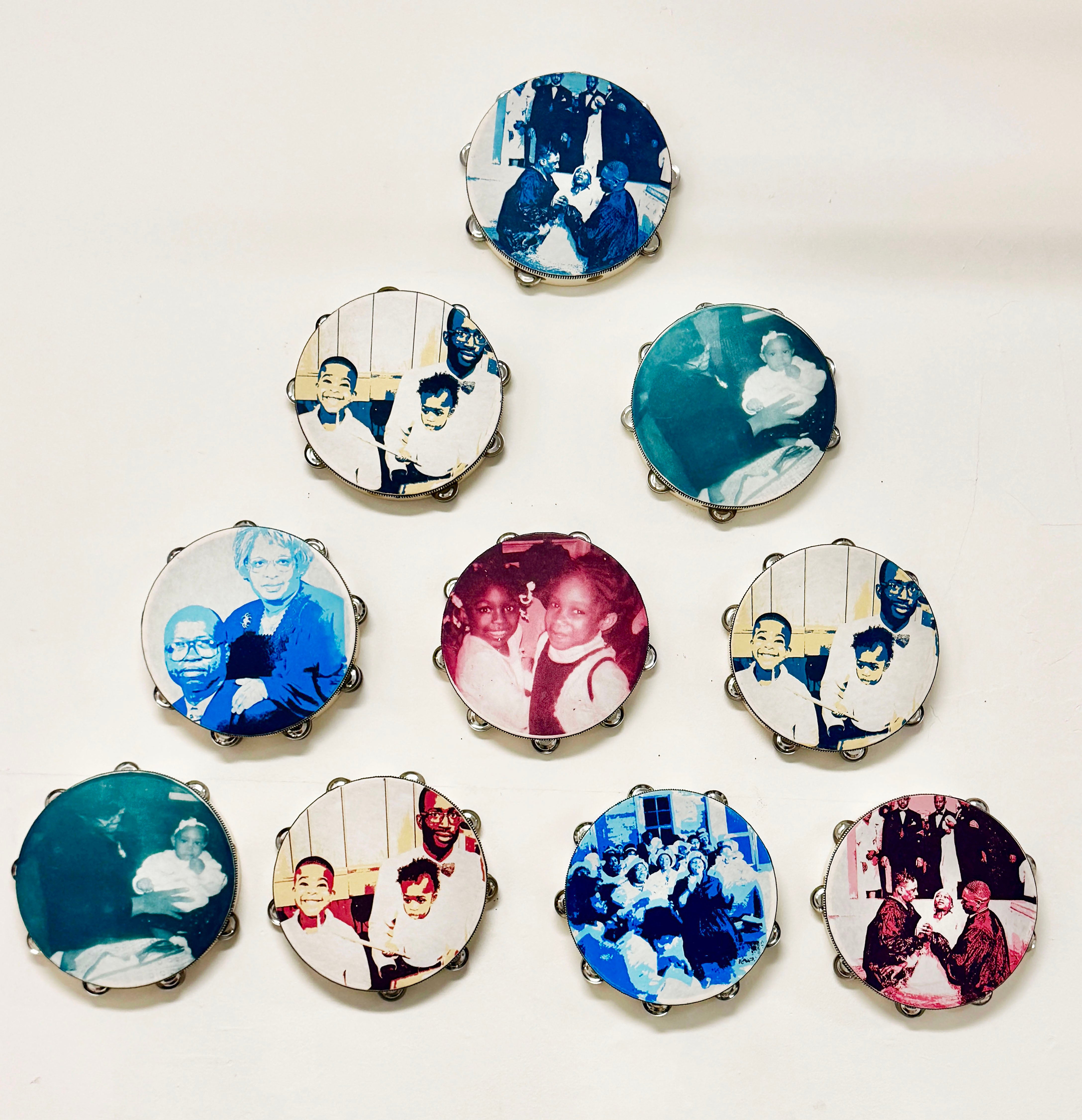 Triangular pyramid of ten wooden tambourines. The faces on the tambourine show magenta, cyan, yellow, and deep purple. Screen-printed portraits of the artist’s family and traditions that occur in a church setting, such as baptisms, praise, and worship.