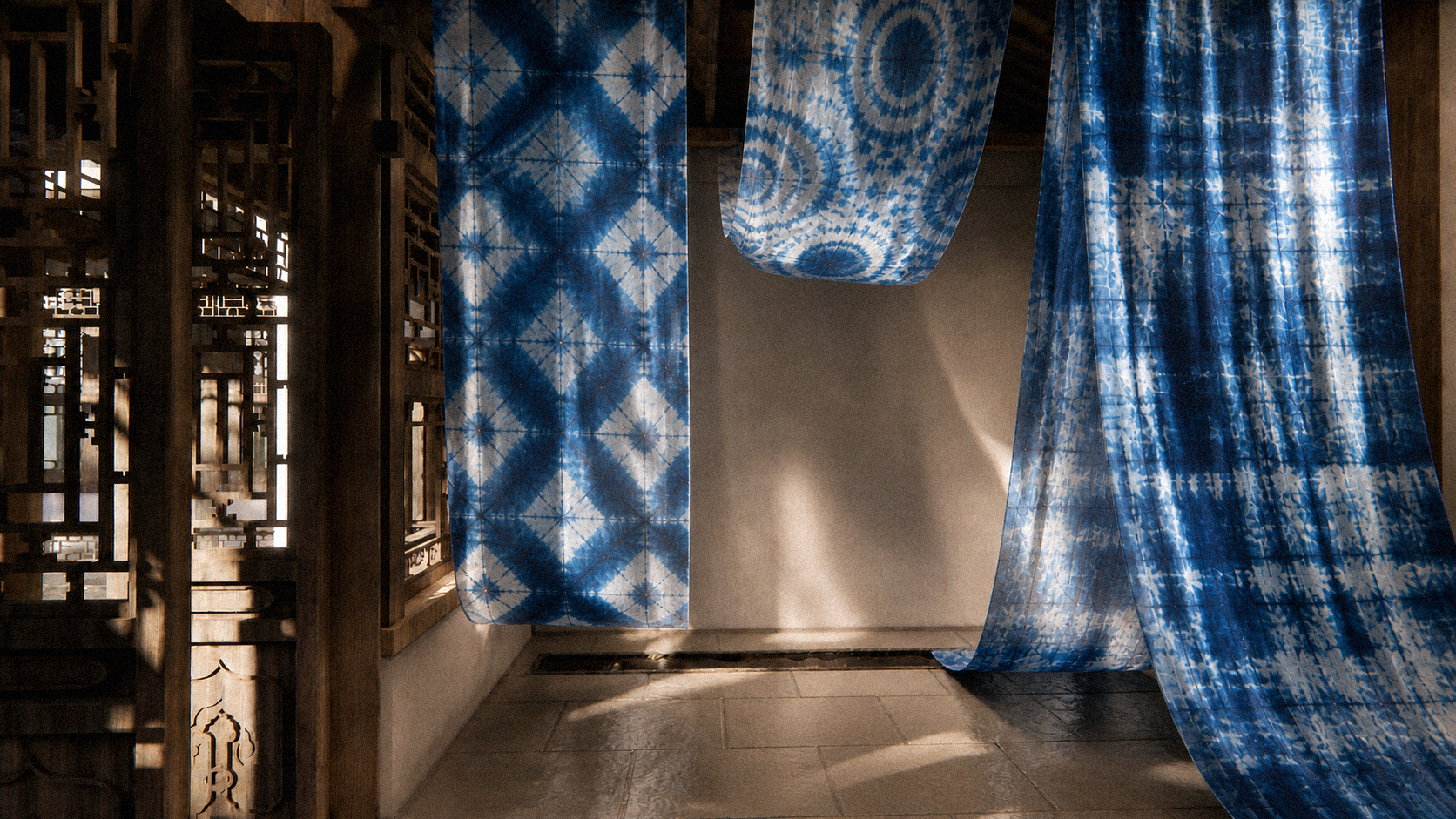 Large indigo dyed fabrics with geometric patterns hang and drape in a sunlit traditional Chinese architecture space, casting soft shadows on stone flooring and creating a calm, atmospheric space.