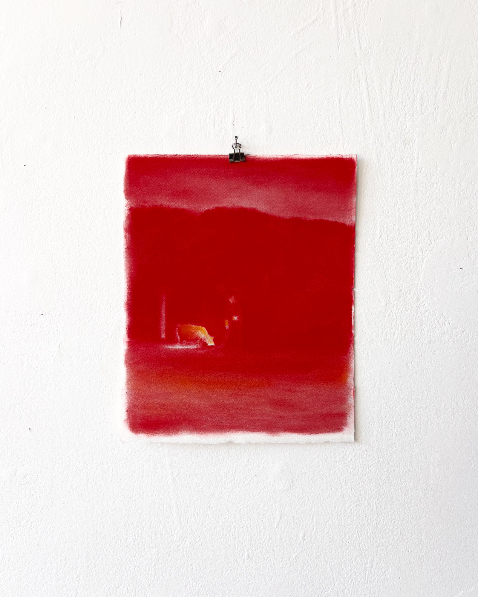 A piece of paper is covered with bright red chalk pastel. It is so red it almost glows. 