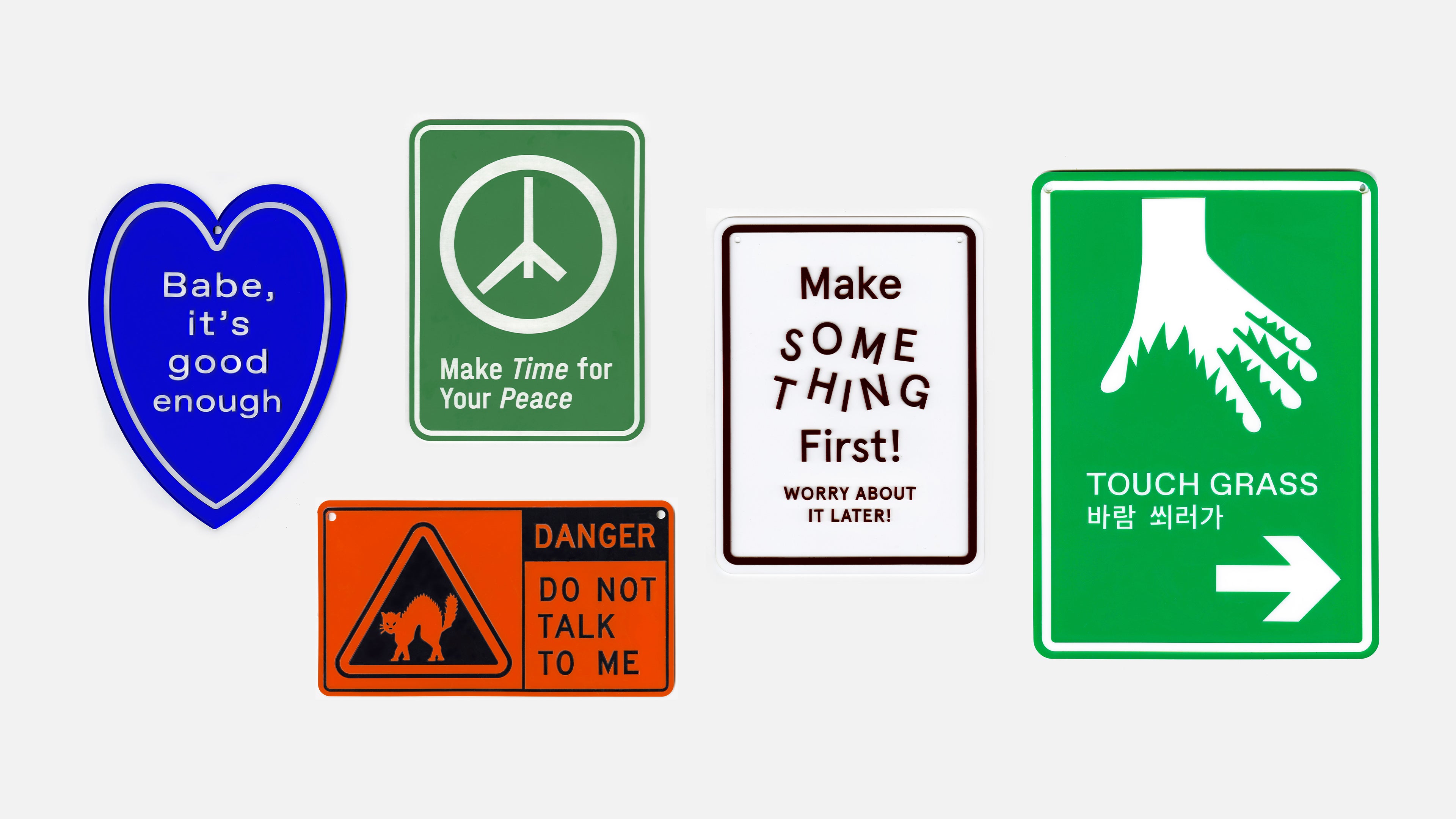A display of five plastic signages in various colors. The design is similar to the style of traffic sign. The text on the signs are words of personal reminders and public announcement.