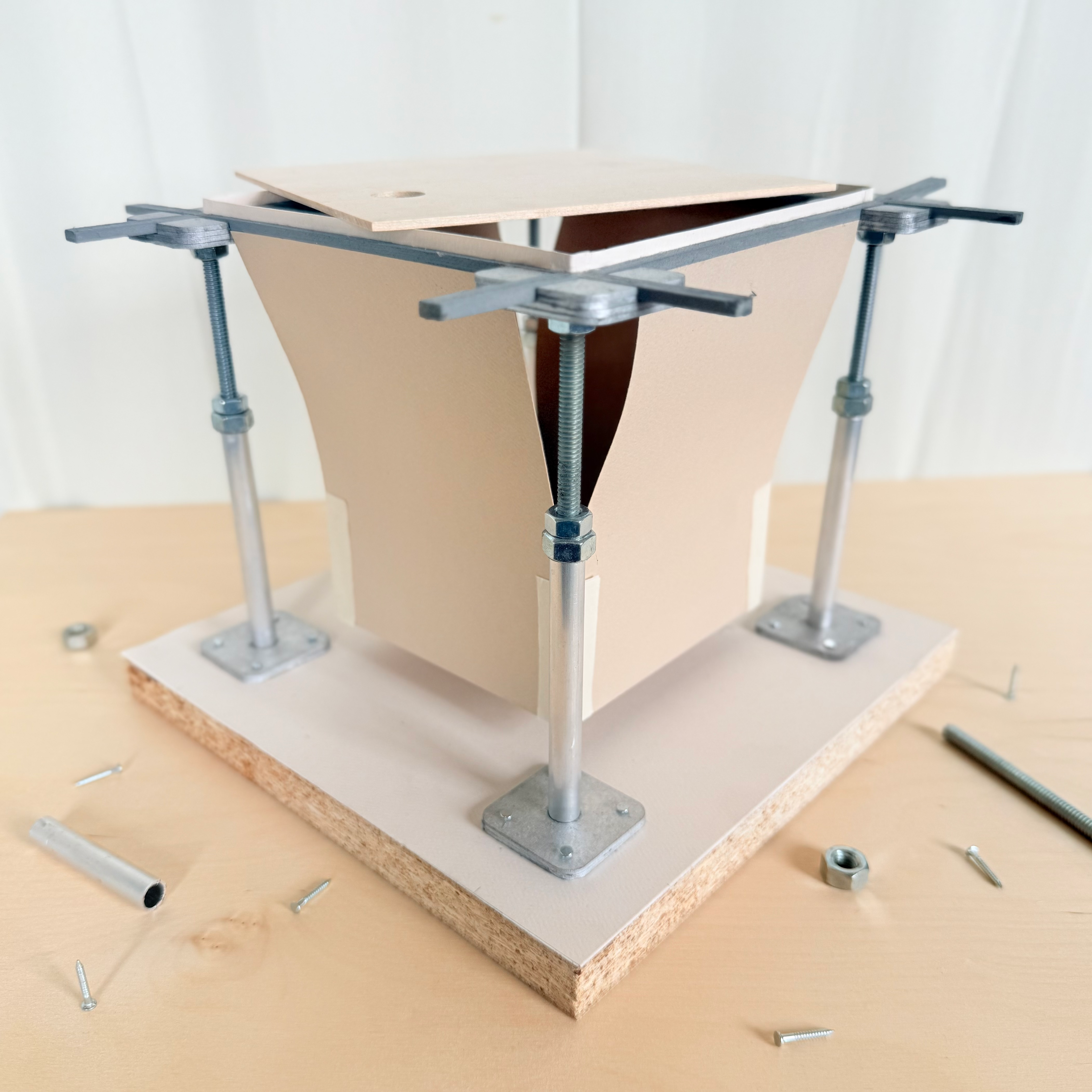 Adjustable metal pedestals on a base support metal stringers holding a wood flooring panel. A storage prototype mounts inside the stringers, and a circular cutout provides access.