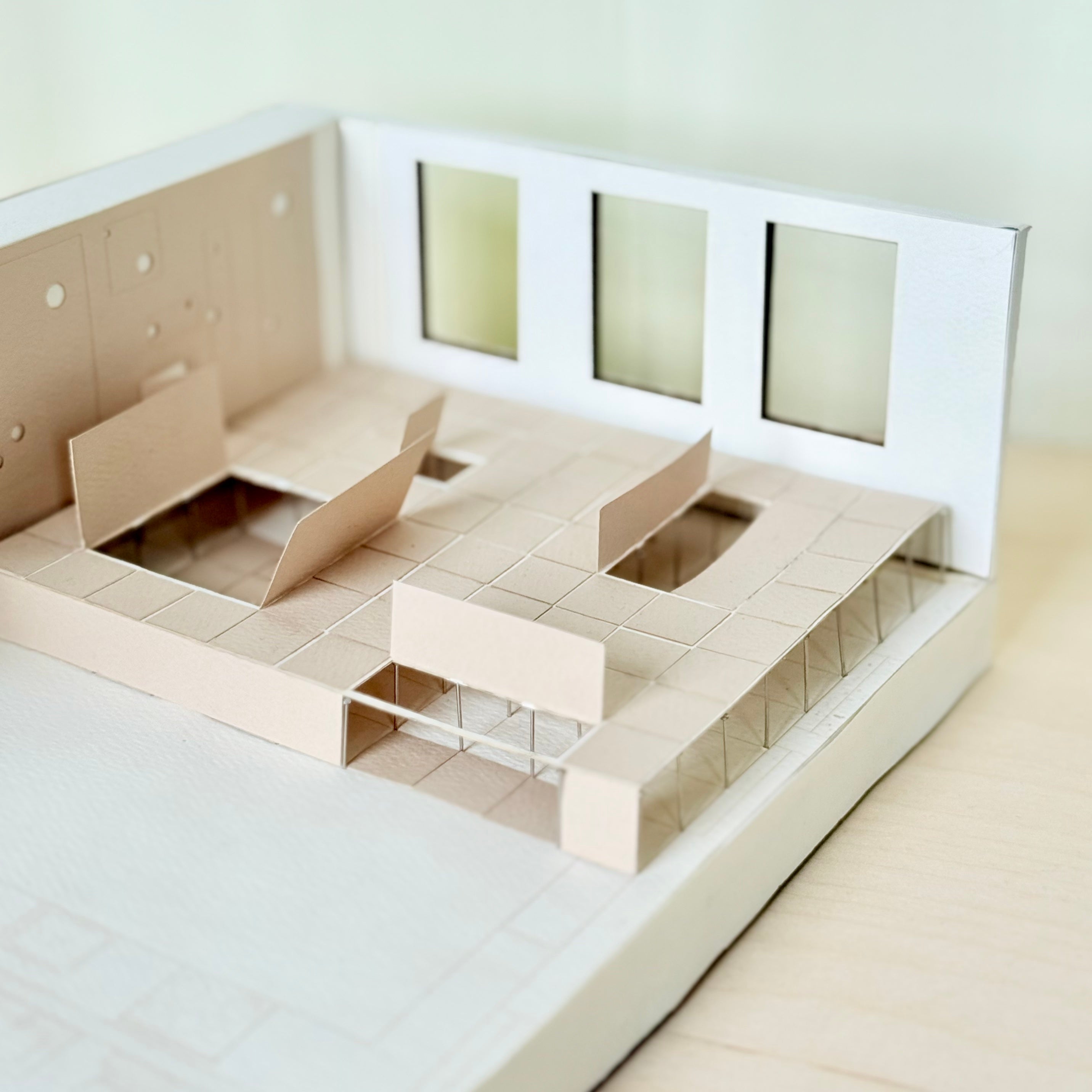 Architectural model showing a raised floor system with cutouts, partitions, and windows, revealing underfloor space and structural supports.