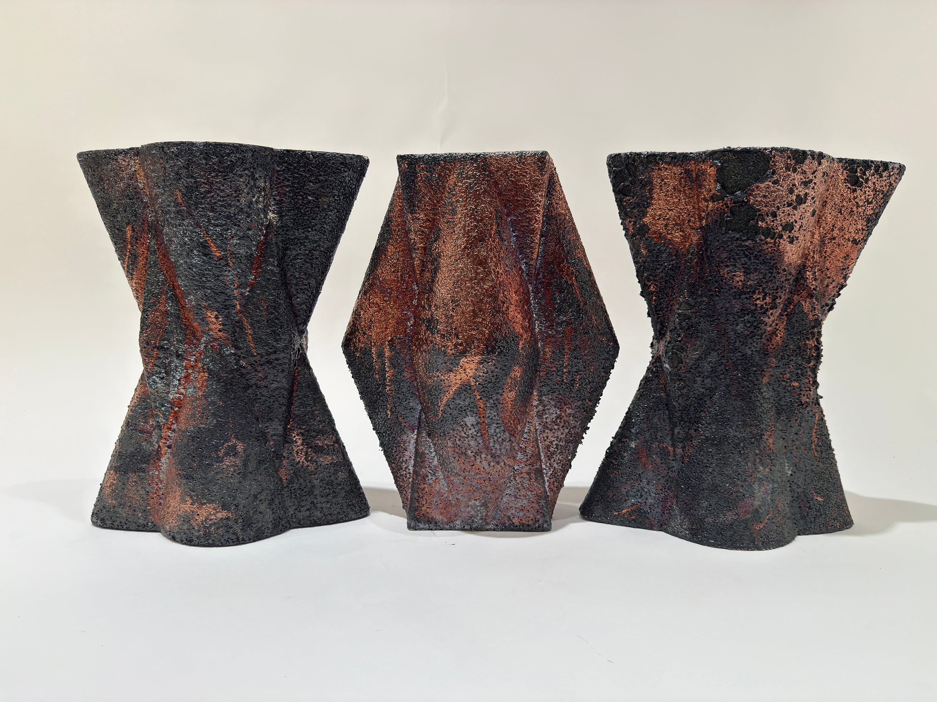 Three shapes of X's and V's align in a row form a pattern.  Their surface is harsh and corse and feels of burnt wood.