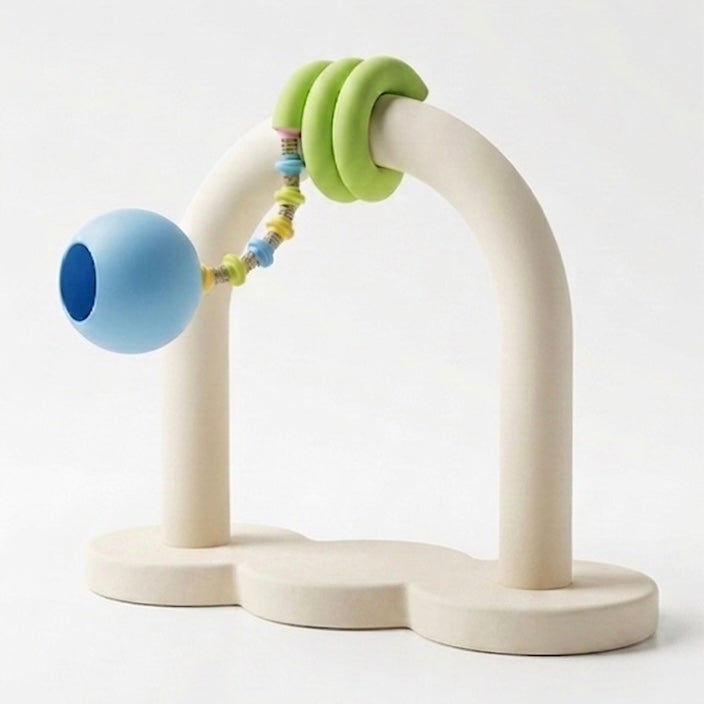 " An arched structure featuring a lighting fixture with a coiled green body and a blue sphere lampshade."