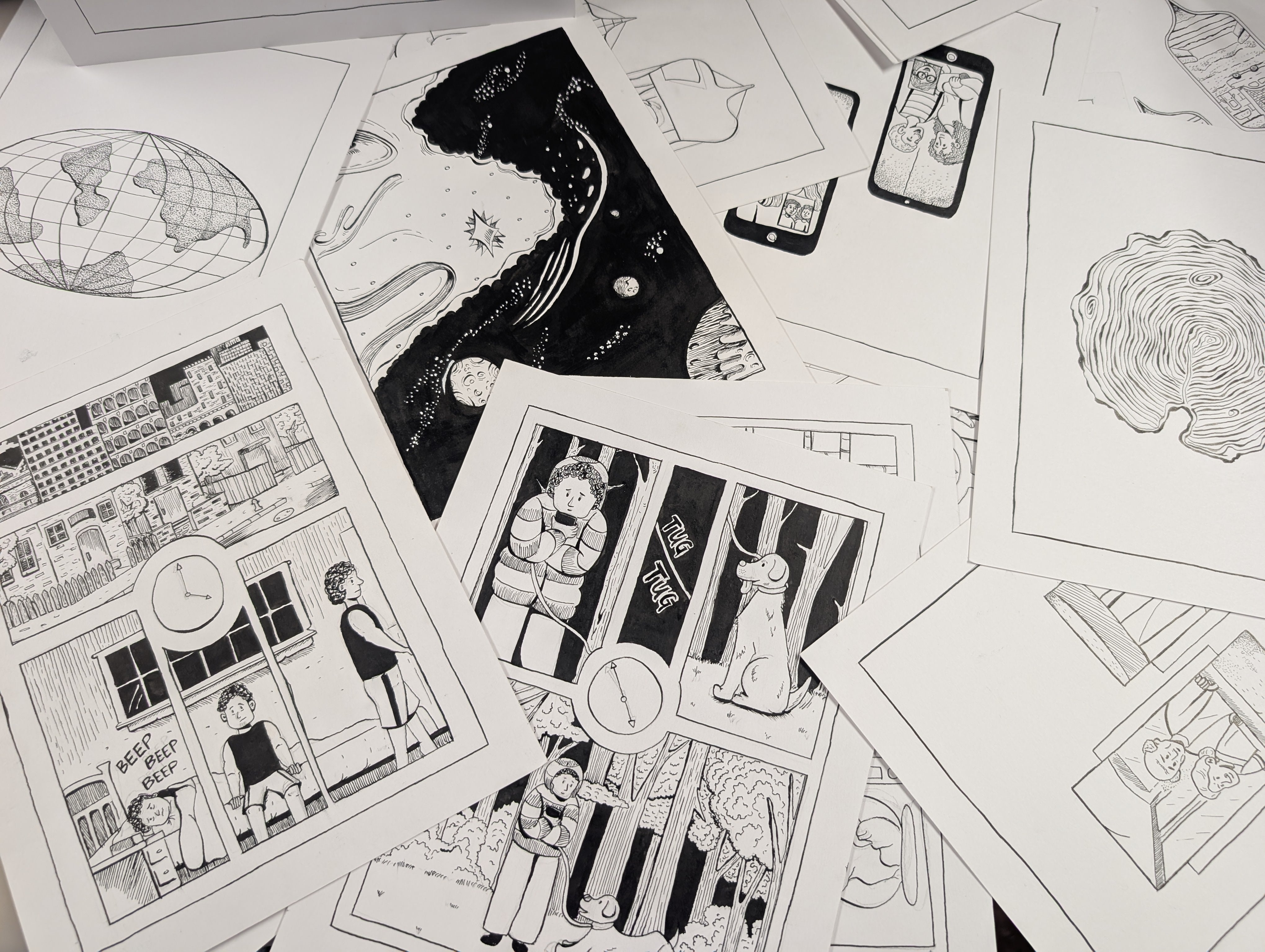 Scattered comic pages showing multiple hand-drawn pages with panels, sketches, and inked line work as a look into the artist's comic-making process.