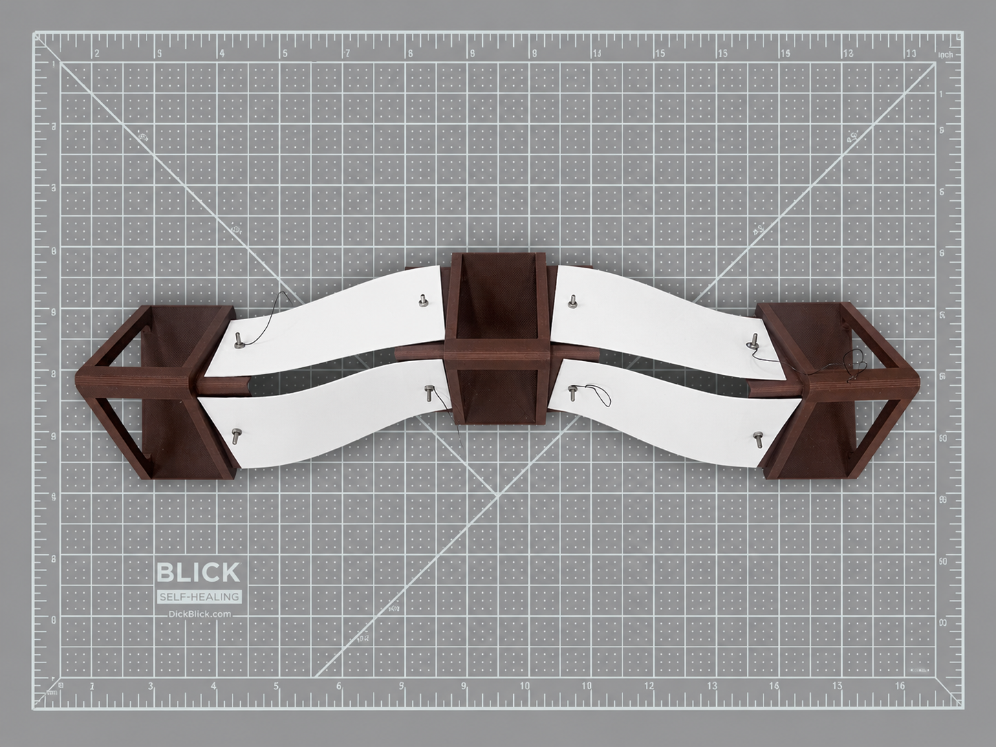 An assembly of three triangular cylindrical components with embedded Nitinol wire, forming the segmented body of Vermis to enable sequential contraction and directional crawling movement.