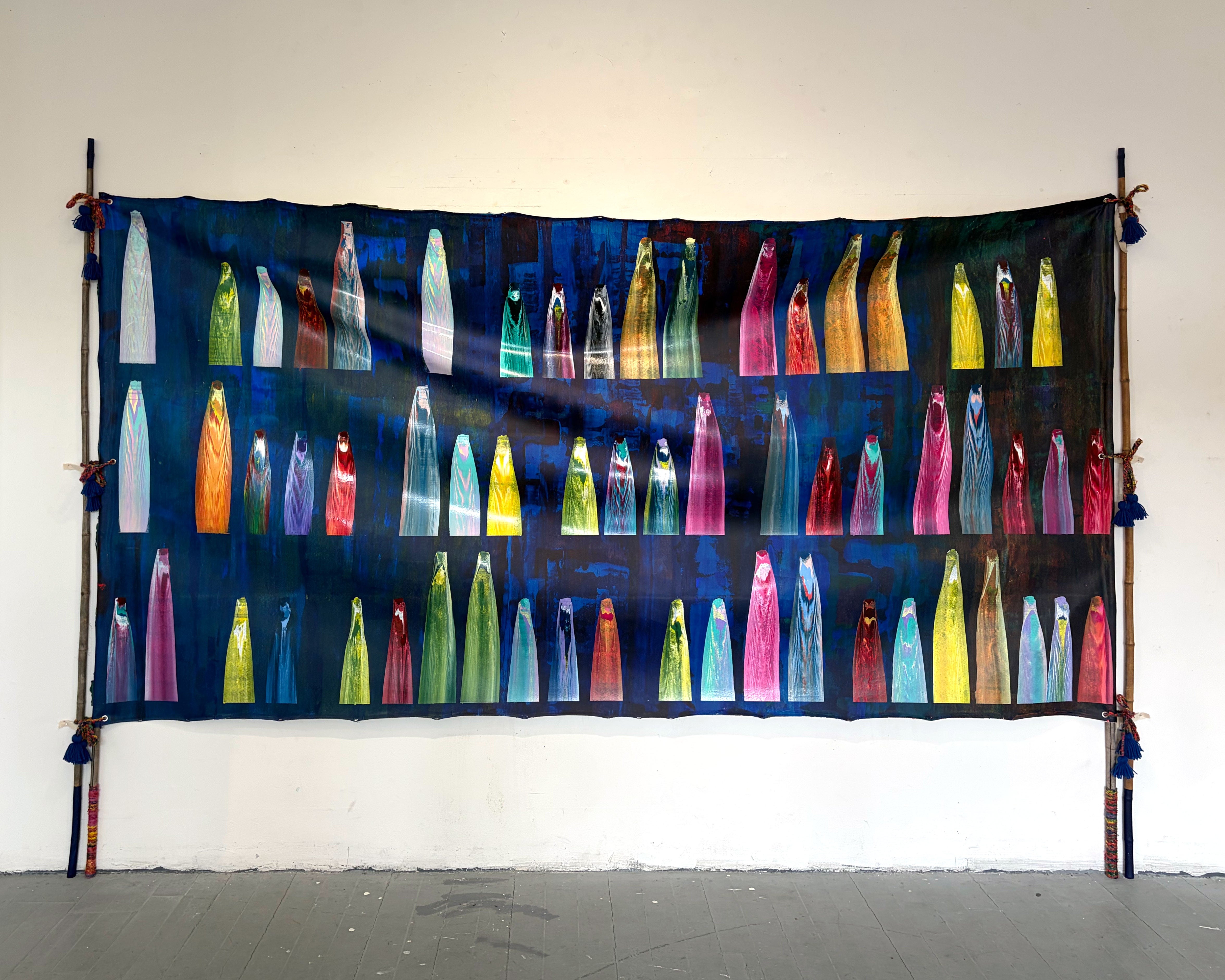 Its a Blue panel, hung through bamboos and ropes. Represents wedding tent structure from South Asia, there are multicolor gestural marks, that personal text in a coded language. 