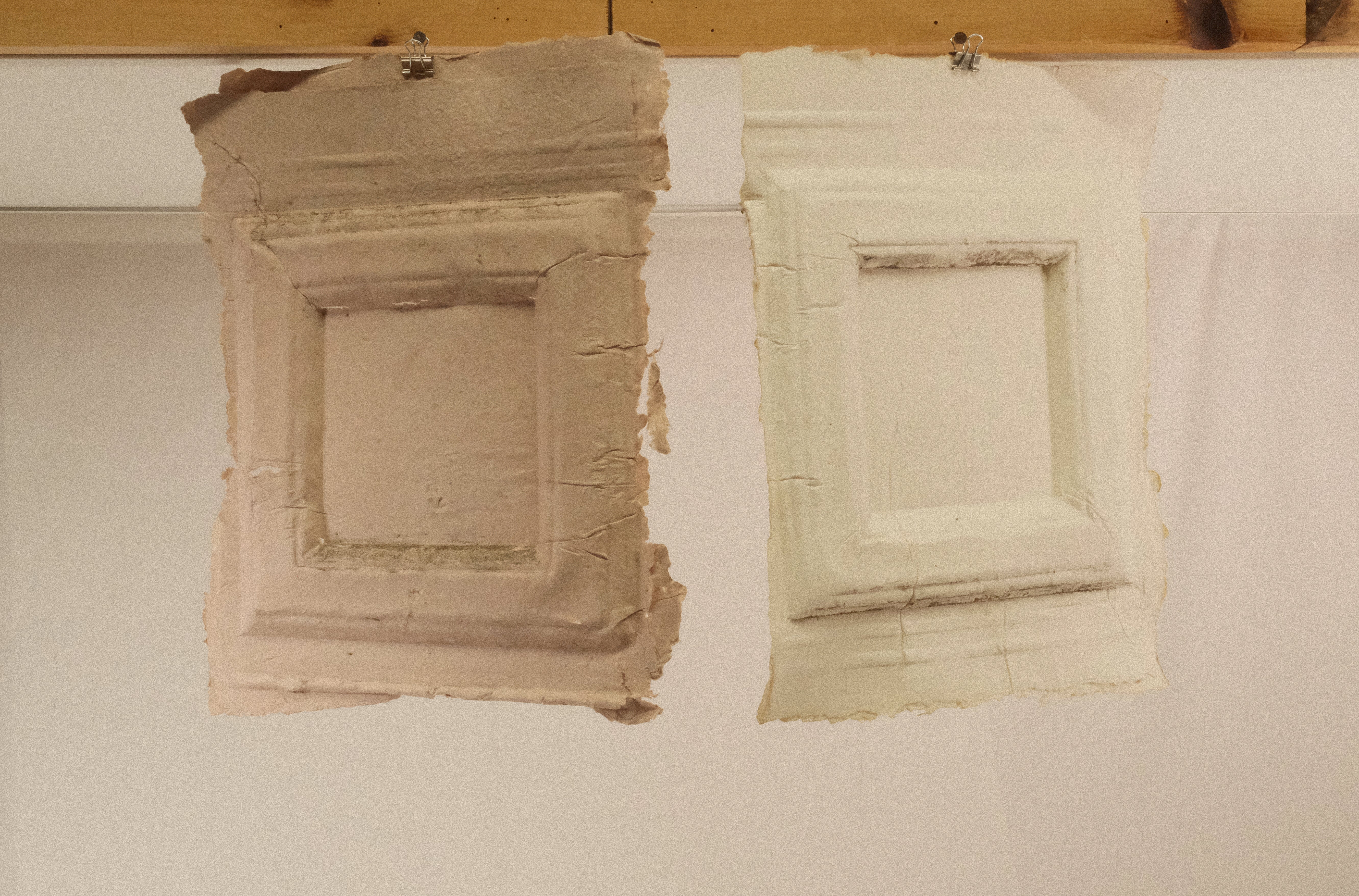 " Two completed paper casts from the vestibule of the Kendrick-Prentice-Tirocchi House, photographed in the studio after drying and removal from the wall. Each sheet carries the irreproducible impression of the surface it received — the ornament, the texture, the accumulated evidence of the space. Brought into the studio, the casts become both record and object, carrying the presence of the wall into a new context. Handmade paper, dimensions variable. 2026"