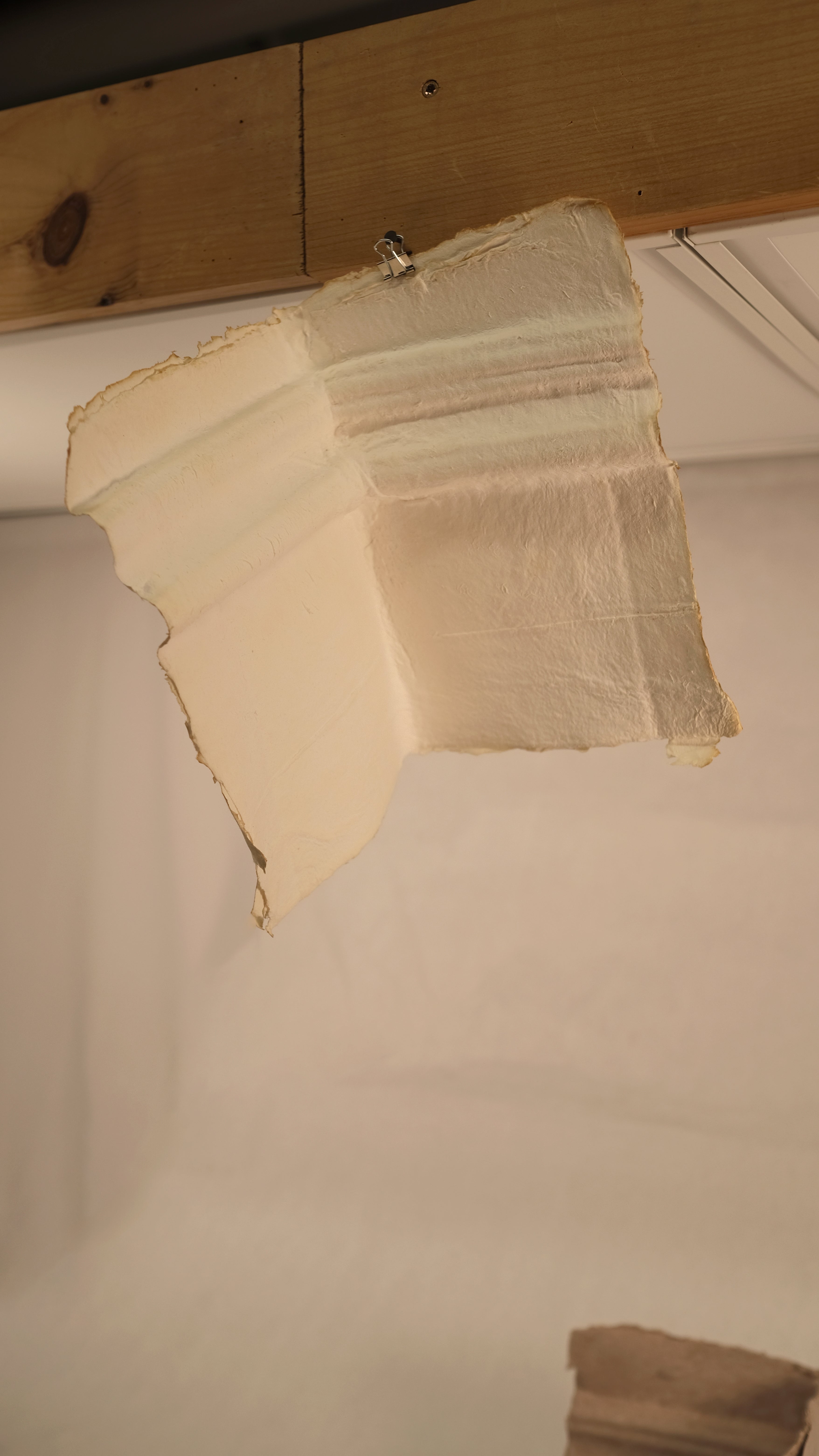 A handmade paper trace revealing the profile of a chair rail molding and corner junction from a historic interior wall.