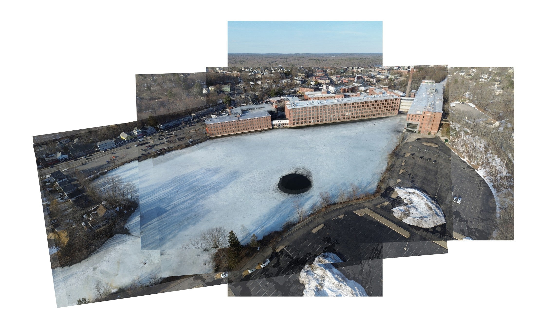 Drone images show the mill complex buildings, pond, and parking lots