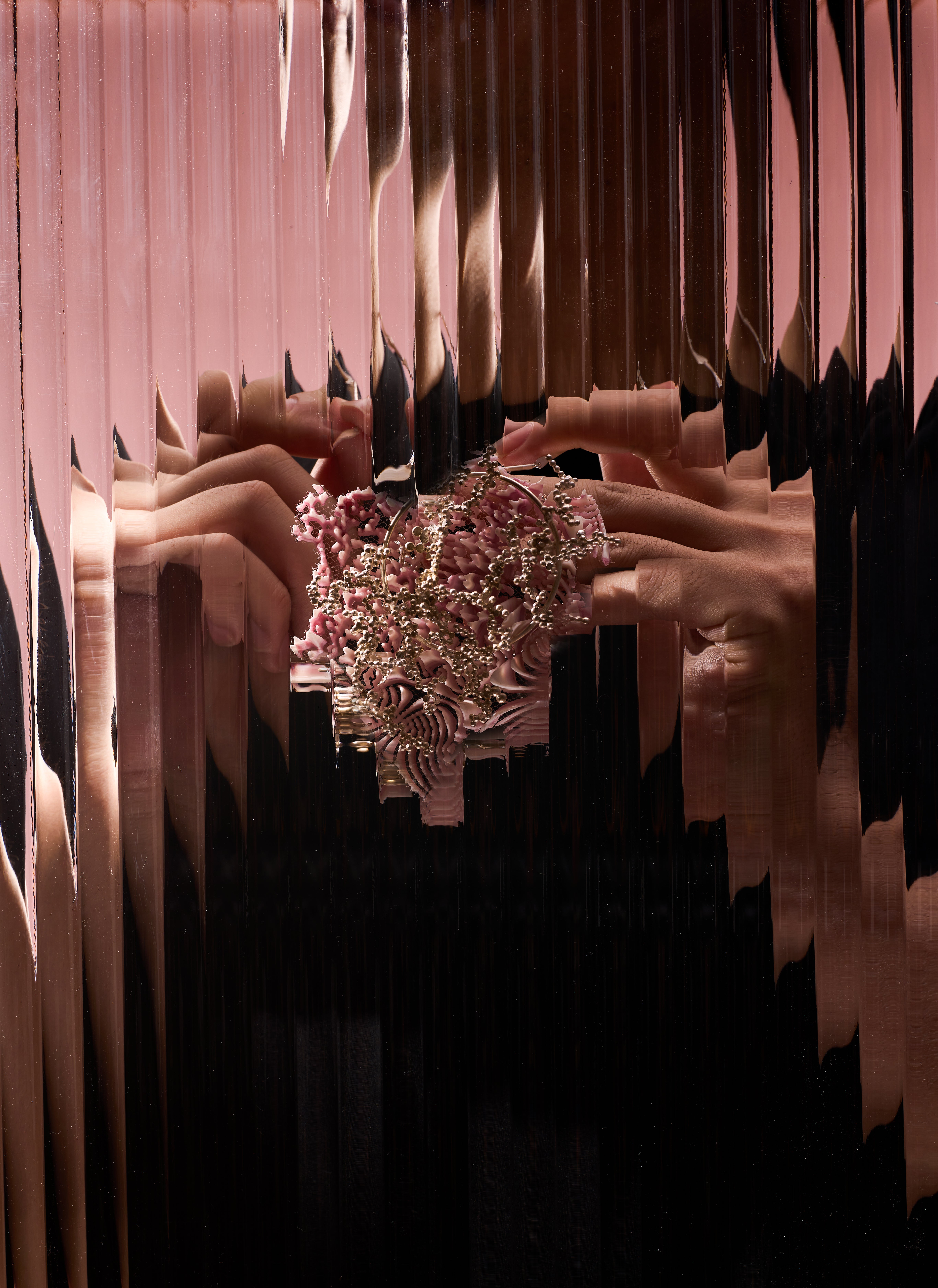 Small pink pendant covered with a network of silver granulation tracing lines across its textured surface.