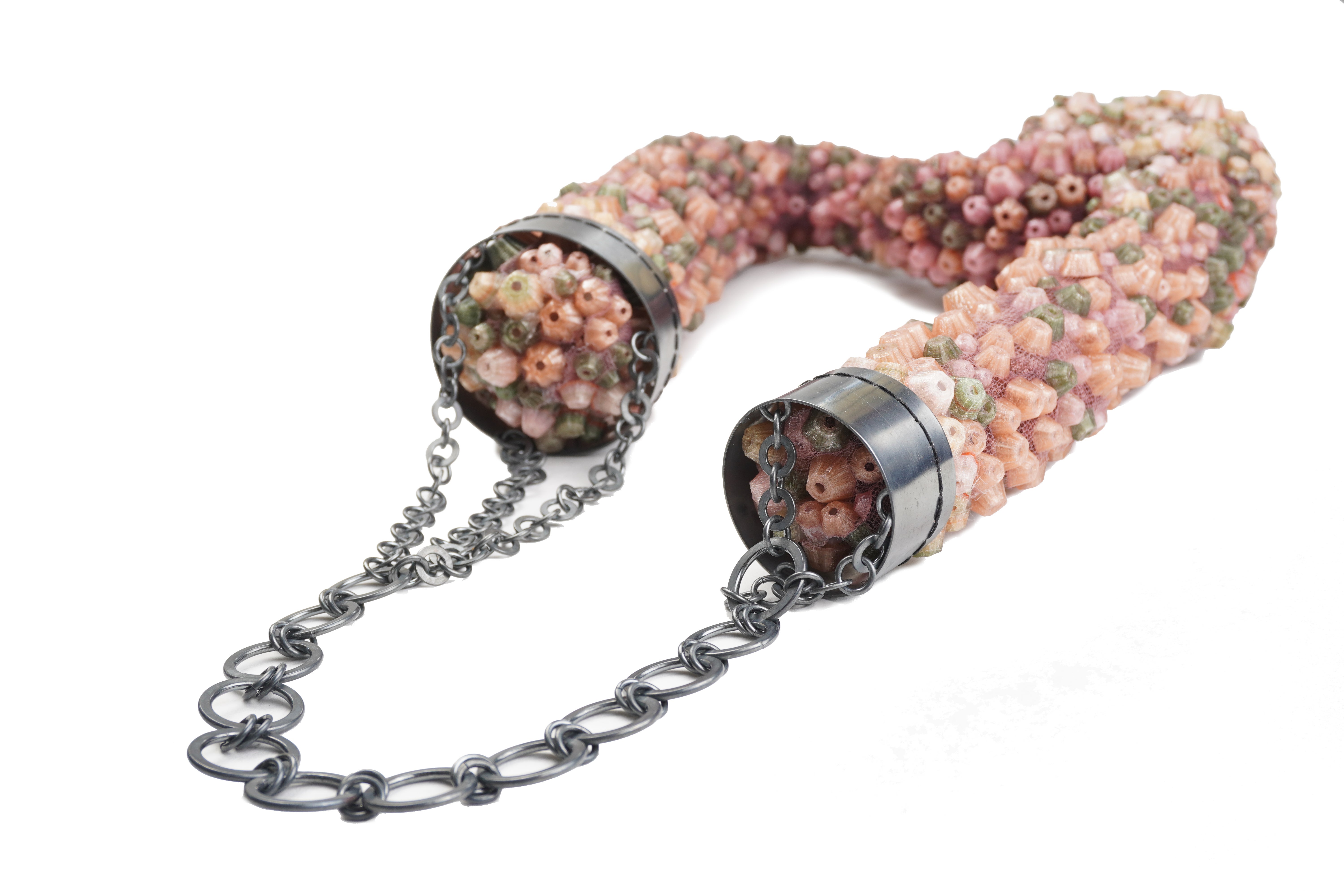 Large necklace covered in dense pink, green, and beige clustered forms on mesh, with an oxidized silver chain wrapping the upper section.