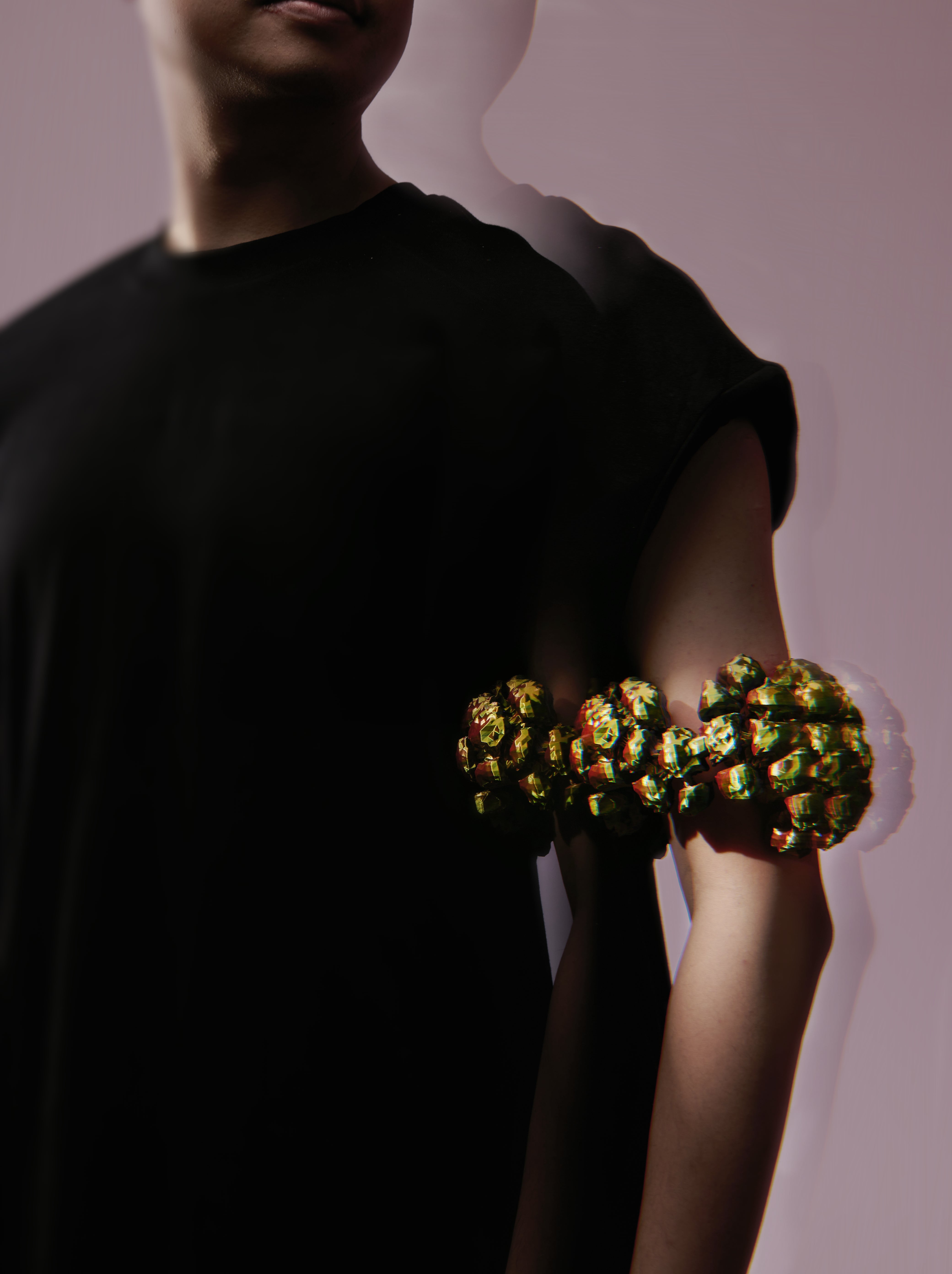 Iridescent purple and pink arm cuff built from clustered rounded volumes that swell outward in a band.