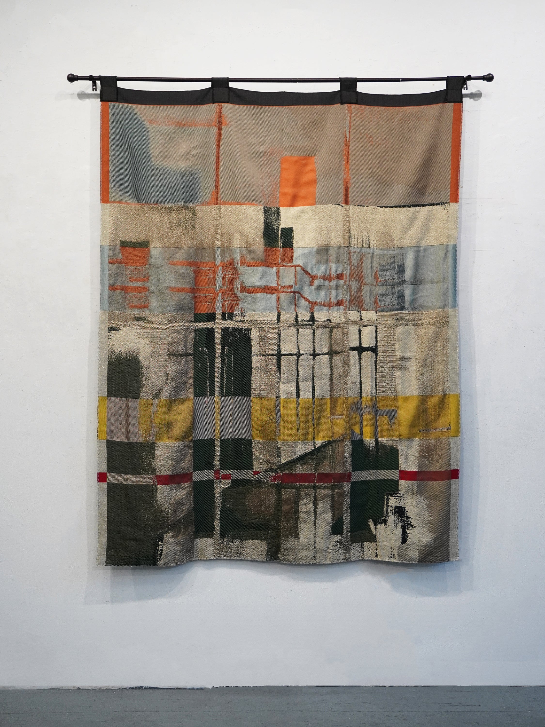 A woven curtain reproducing a painting of a courtyard viewed from within. The composition is divided by a window grid opposite, its panes structuring fields of warm sunset-lit color