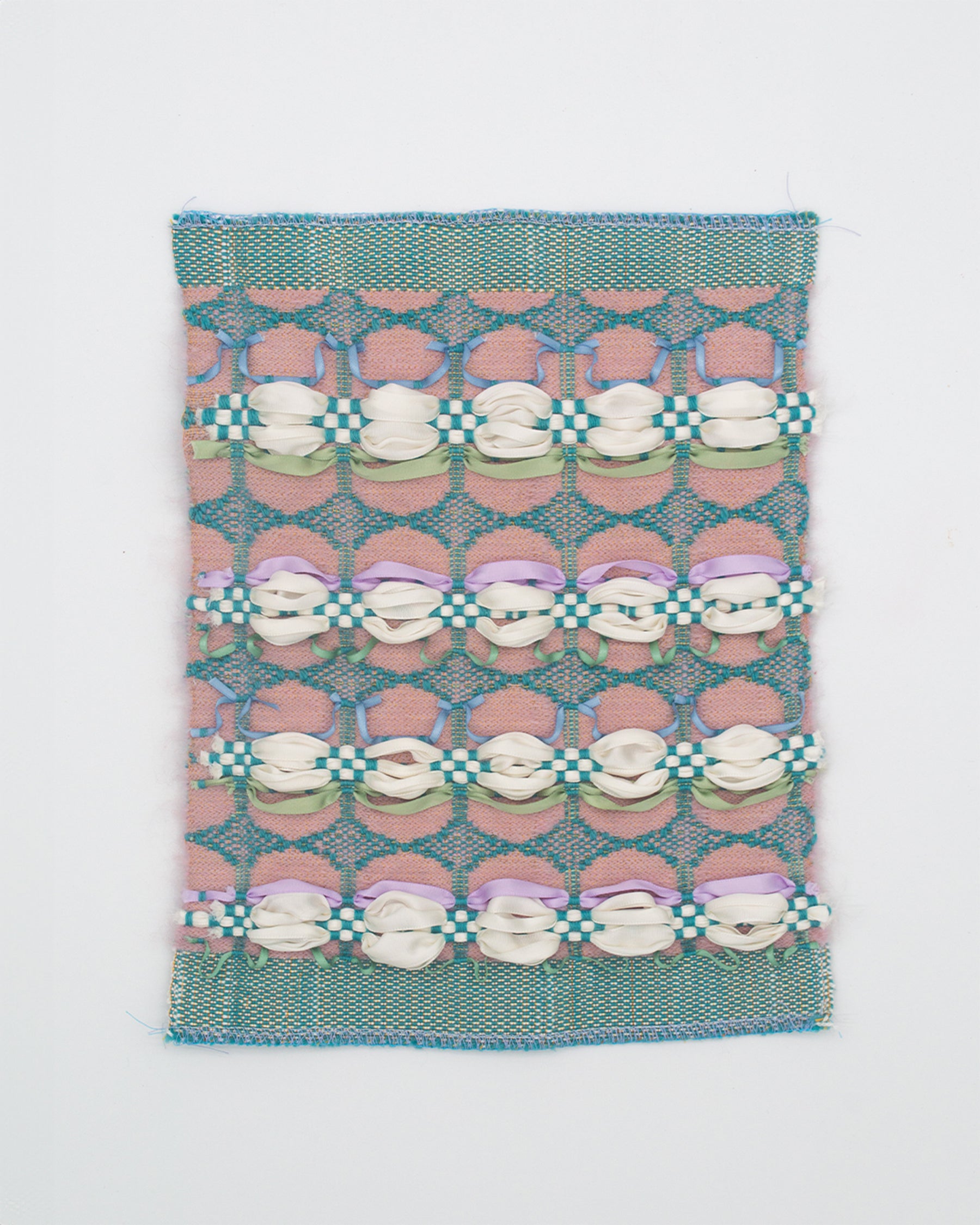 A woven fabric with a teal lace pattern surrounding desaturated pink oblongs. White ribbons form voluminous curves across the surface, resembling piped cream, anchored by a teal checkered weave
