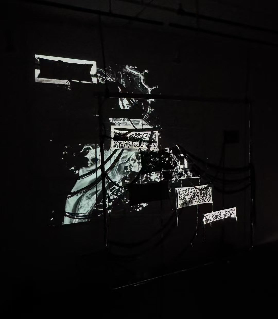 An installation featuring projection-mapped visuals of flowing, patterns inspired by Binary system across layered textile panels
