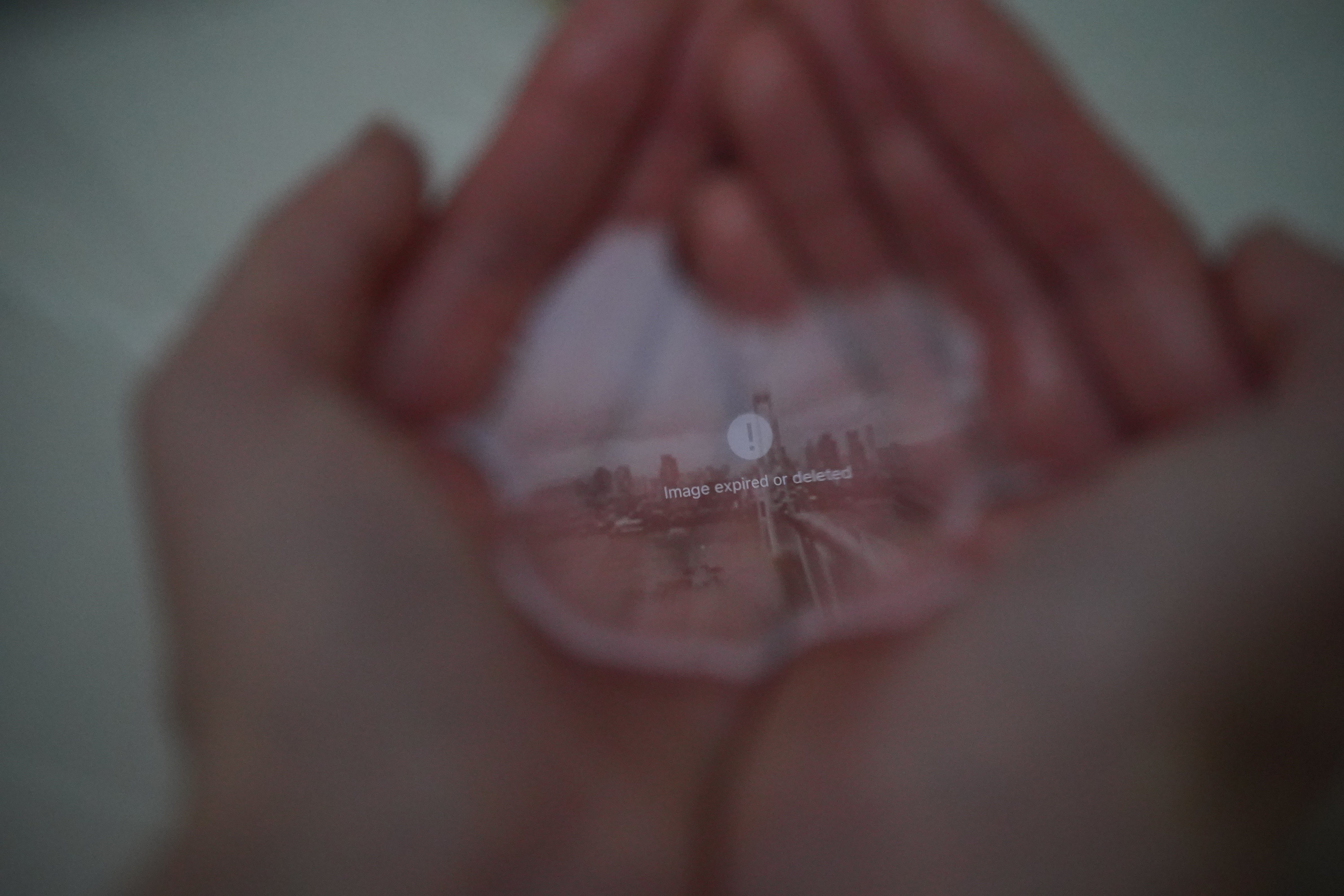 hands hold water with an image reflected on its surface; as the water continuously slips away, the image gradually disappears along with it.