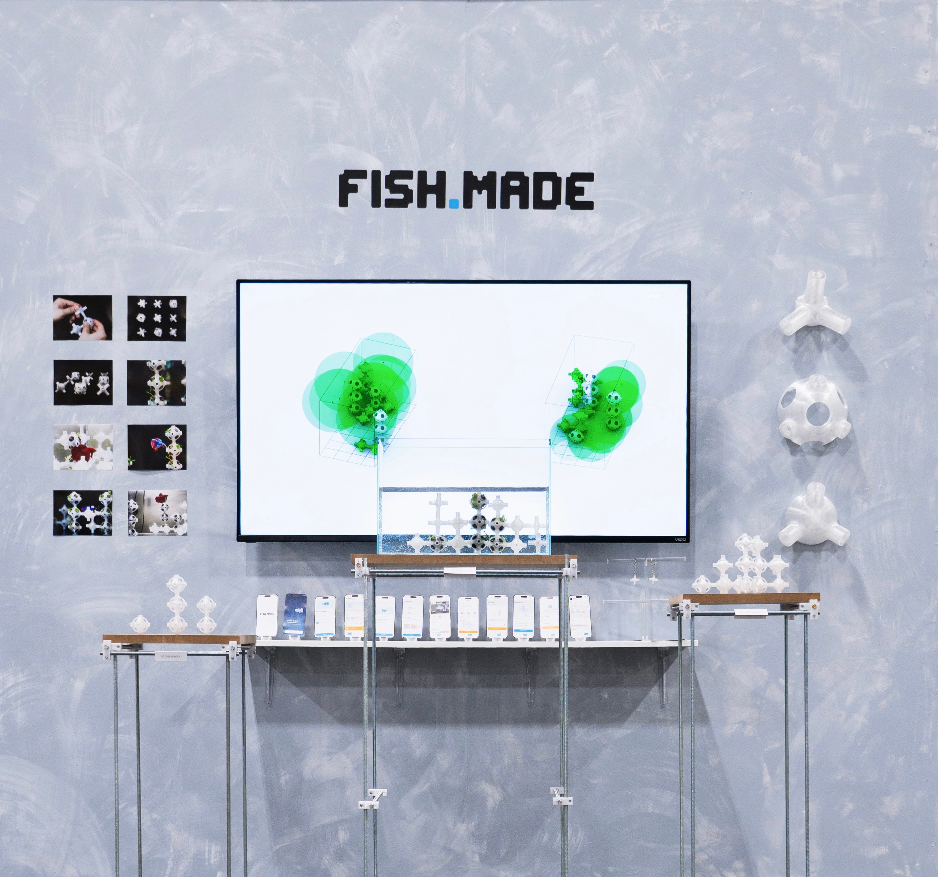 FISH.MADE installation showing the final modular fish habitat inside the tank, with prototype images, app screens, and 3D-printed modules displayed around the screen.