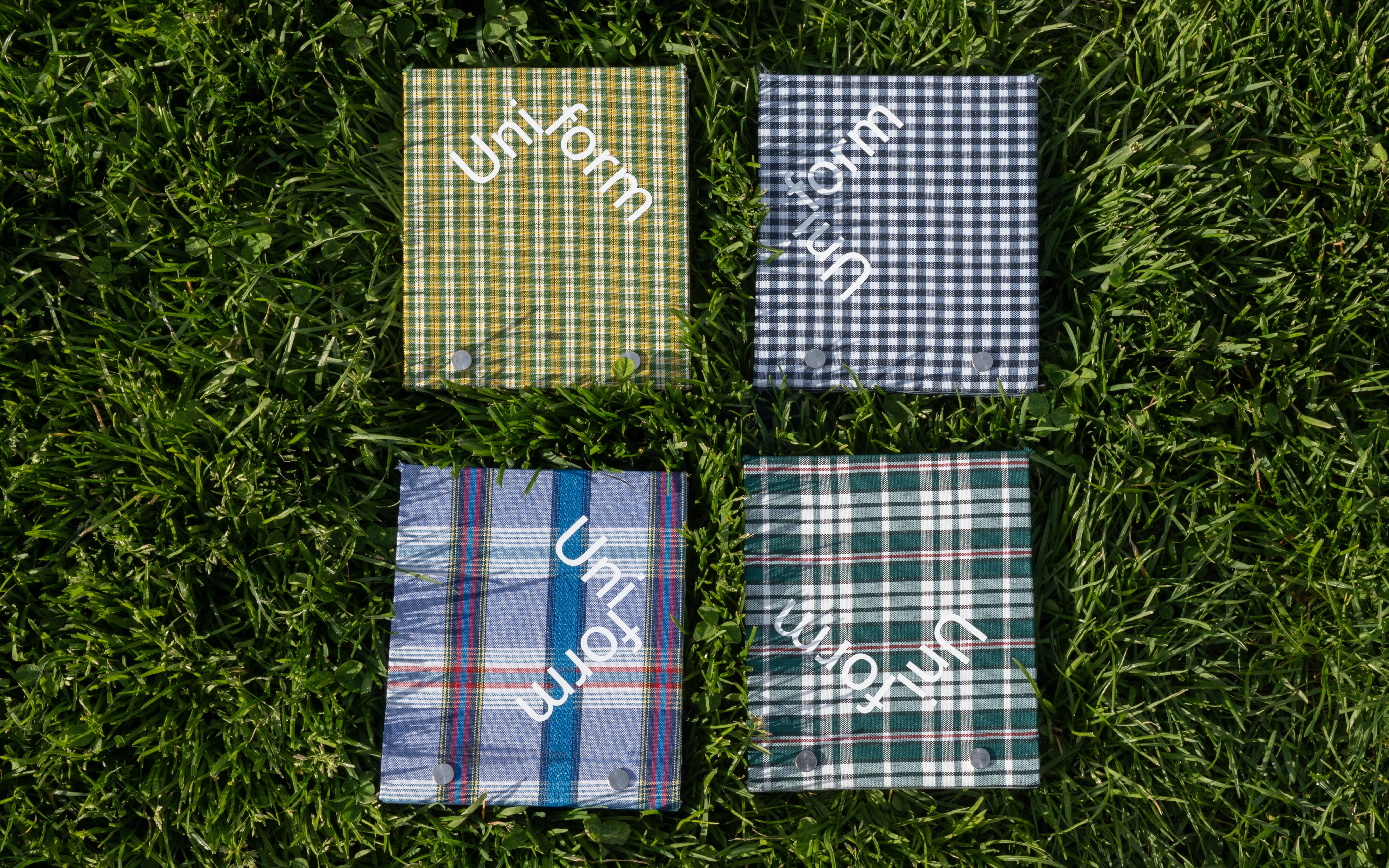  A set of four flipbooks bound in hardcover made from actual plaid school-uniform fabric, each one progressively zooming into the textile's woven pattern.