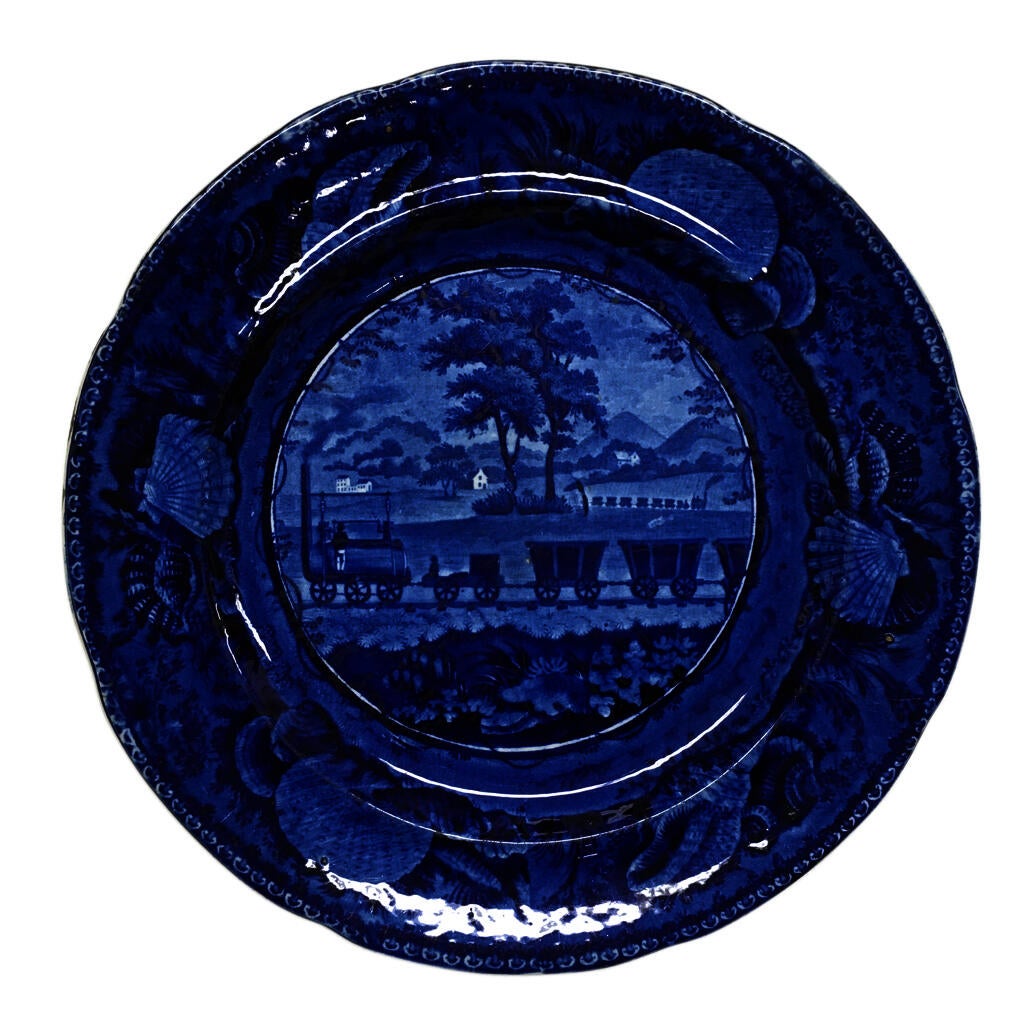 blue and white transferware plate depicting a railroad