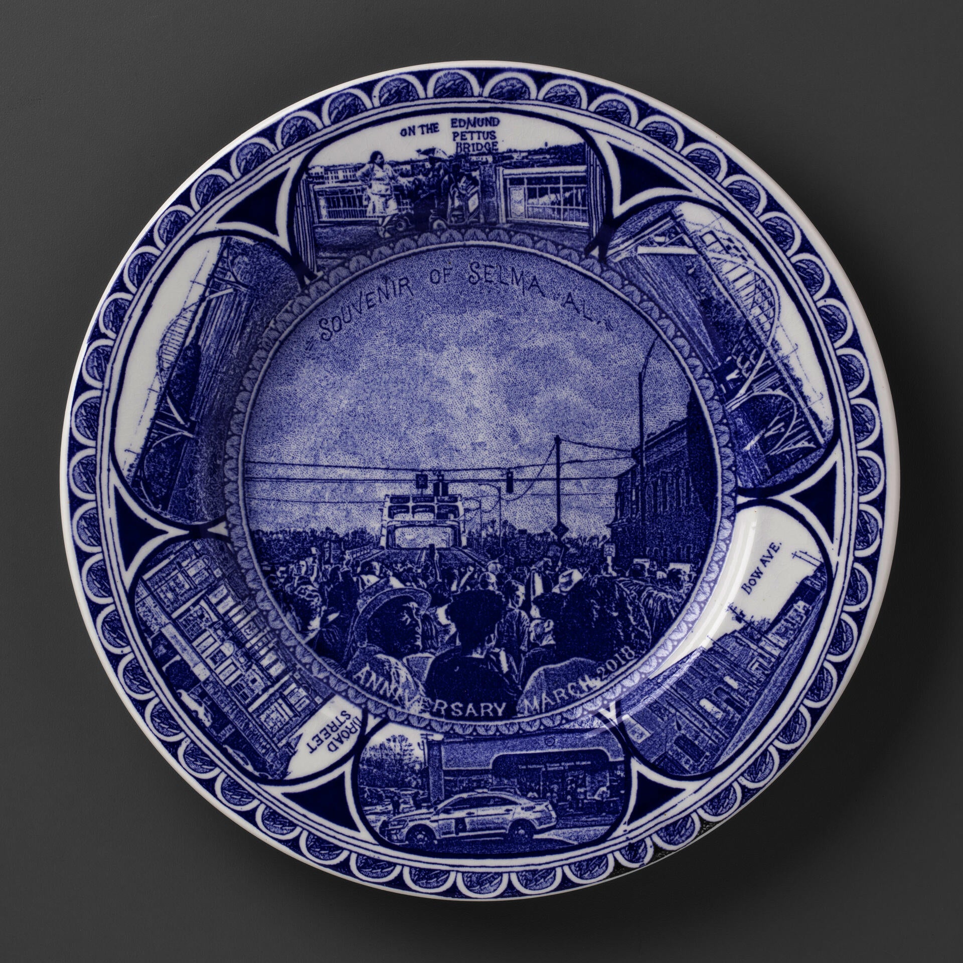 blue and white transferware plate depicting scenes of Selma, AL, featuring a march across the Edmund Pettus Bridge