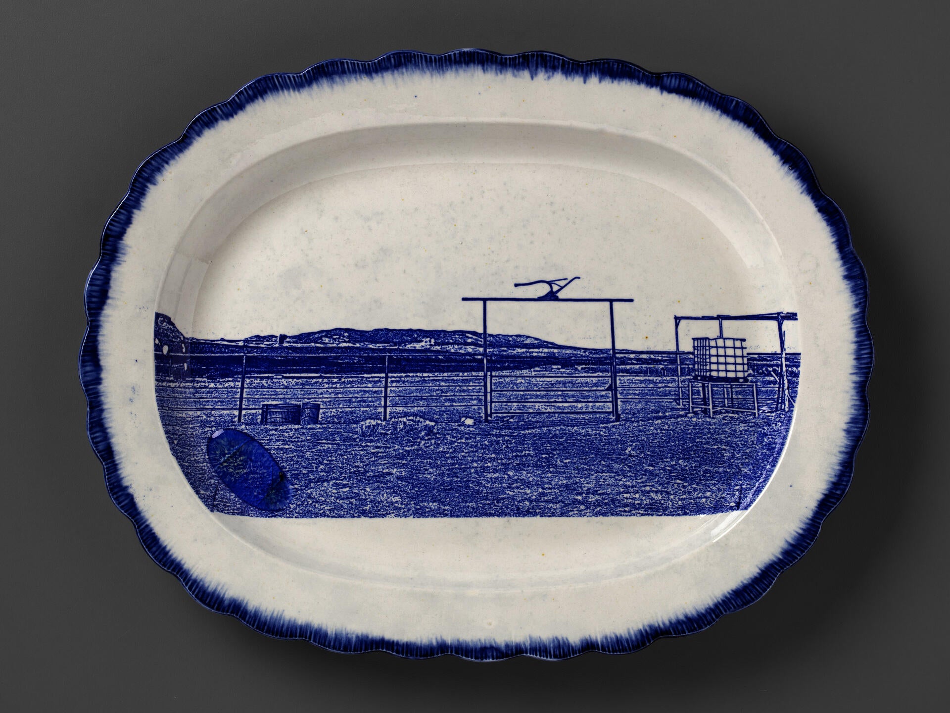 blue and white transferware platter depicting a farmstead near Cove, AZ, with melted Uranium glass on the surface