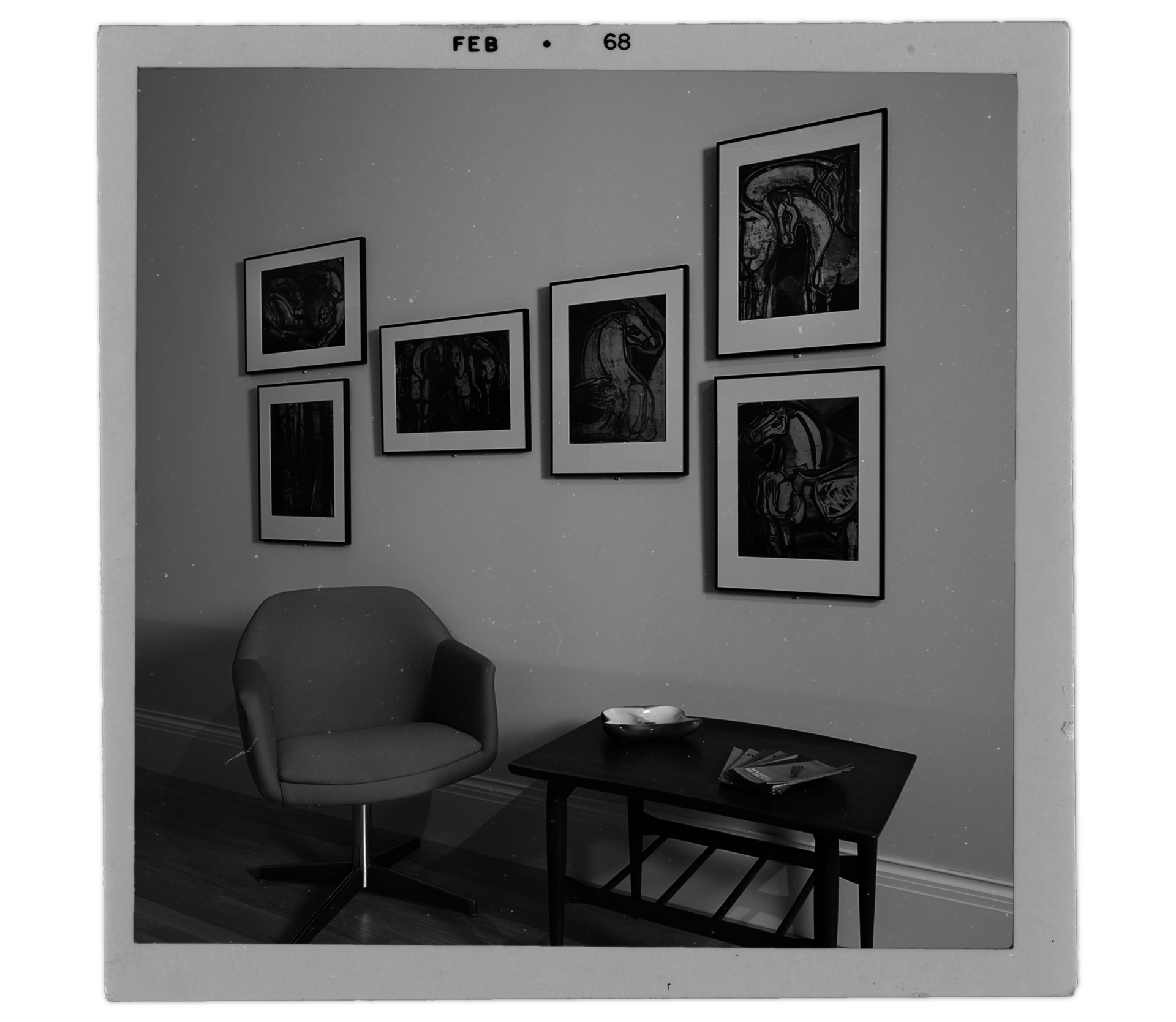 "Old" photograph of six Delia del Carril prints hanging on a wall above a midcentury chair and table