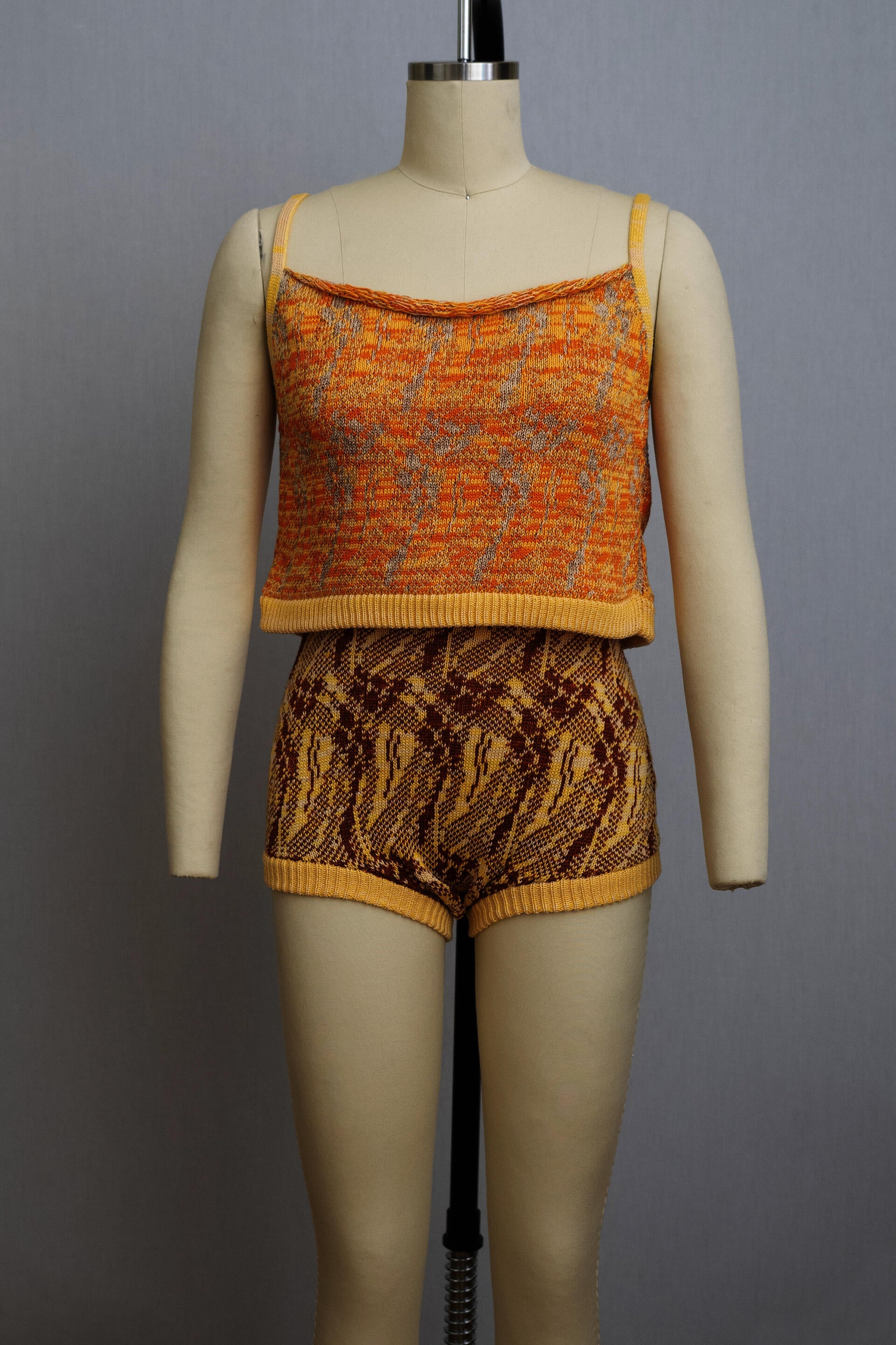 dress form wearing a knit playsuit in oranges and yellows