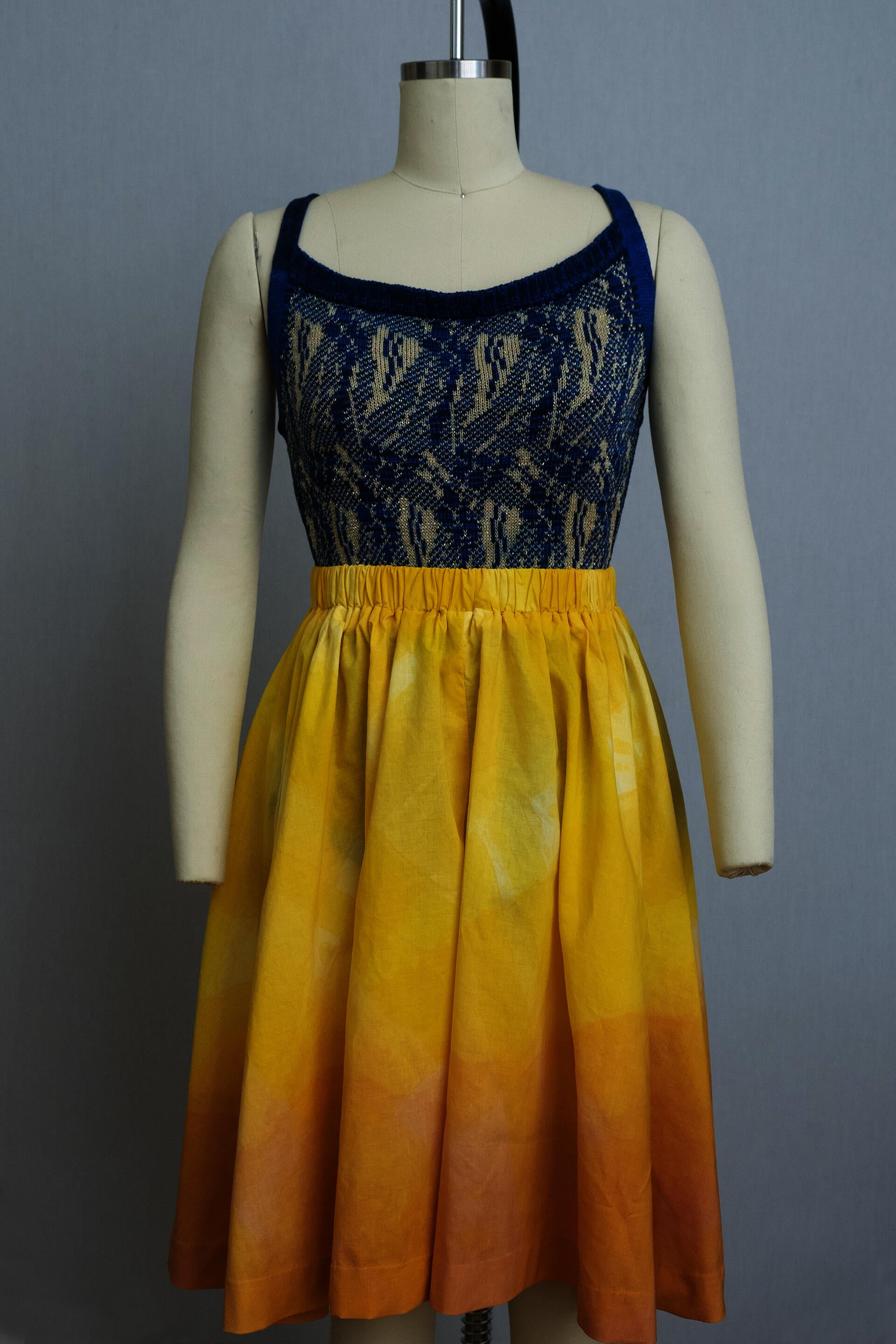 dress form wearing blue knit playsuit and wide leg pants in an orange-yellow ombre