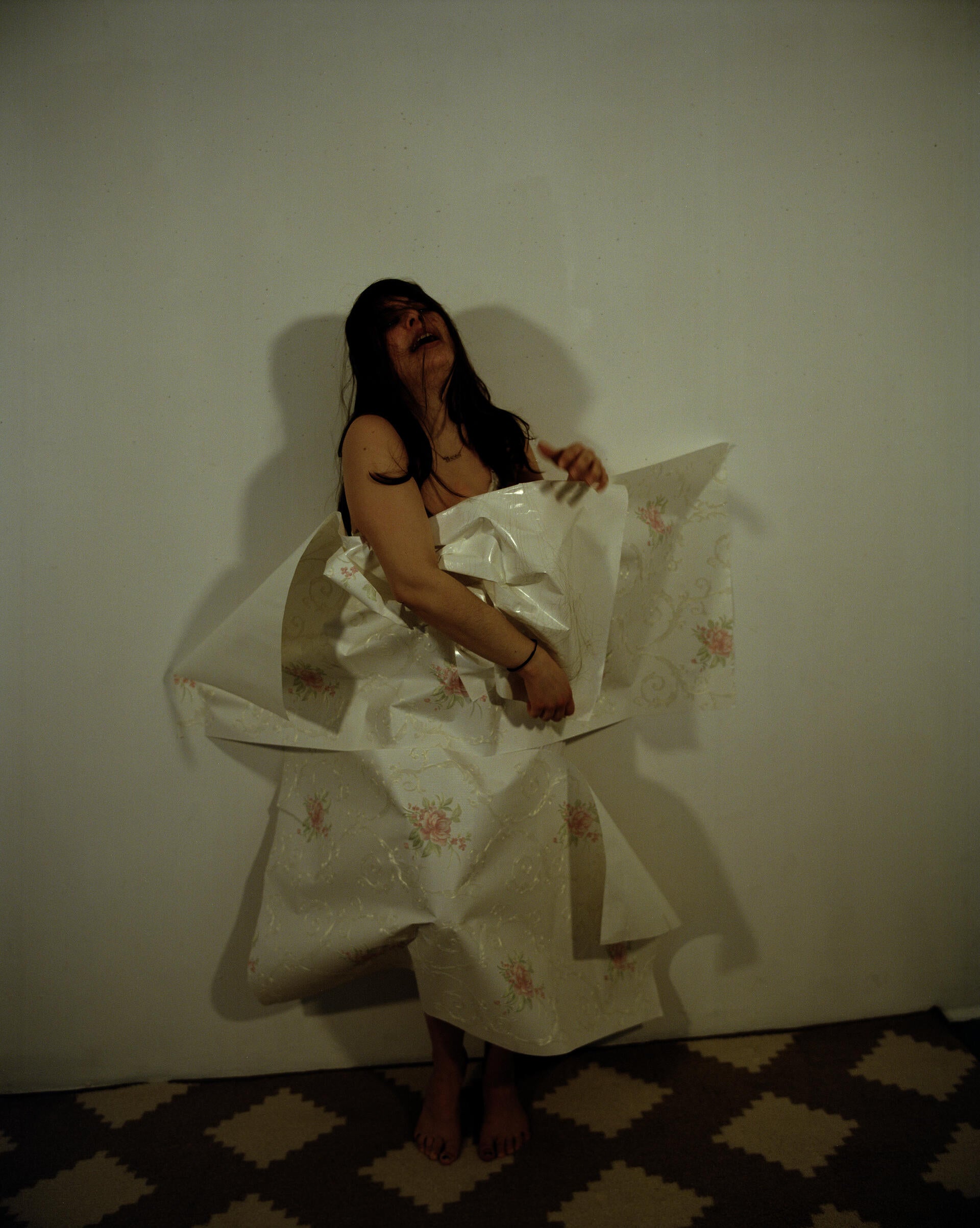 A woman breaking out of wallpaper, which she was sealed into