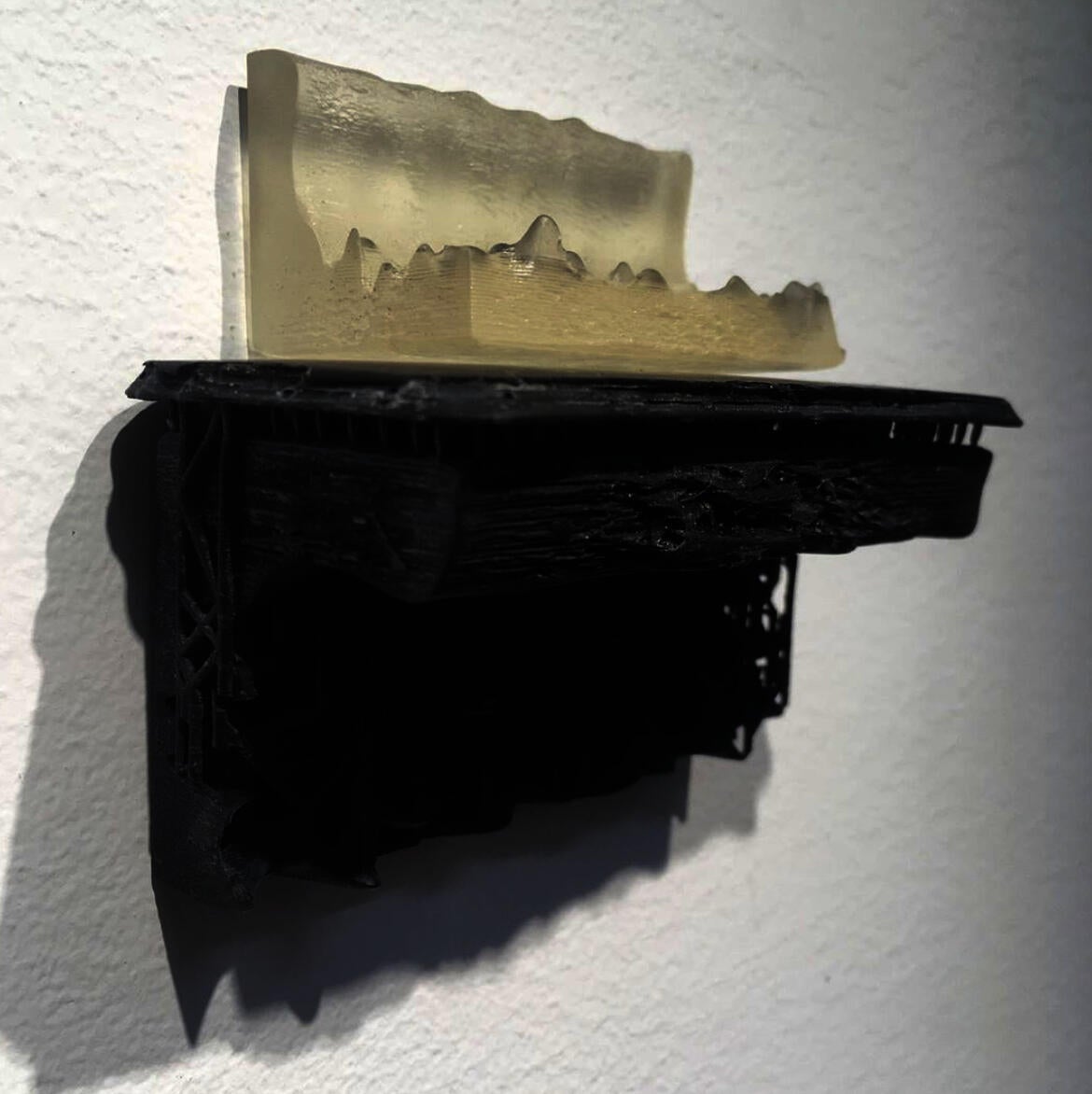 A clear representation of 3D printed waves rests on a black 3D printed mantle.