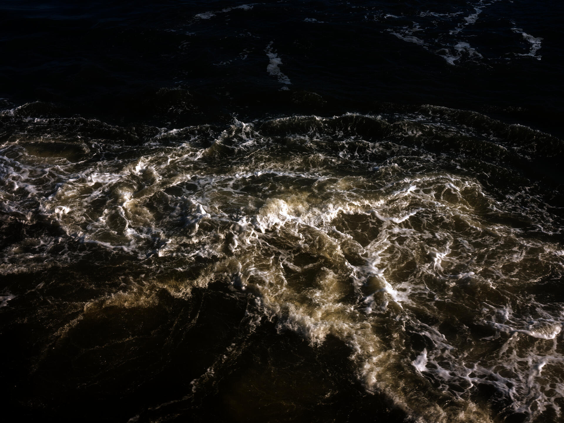 Color photograph of water churning in the Hudson River.