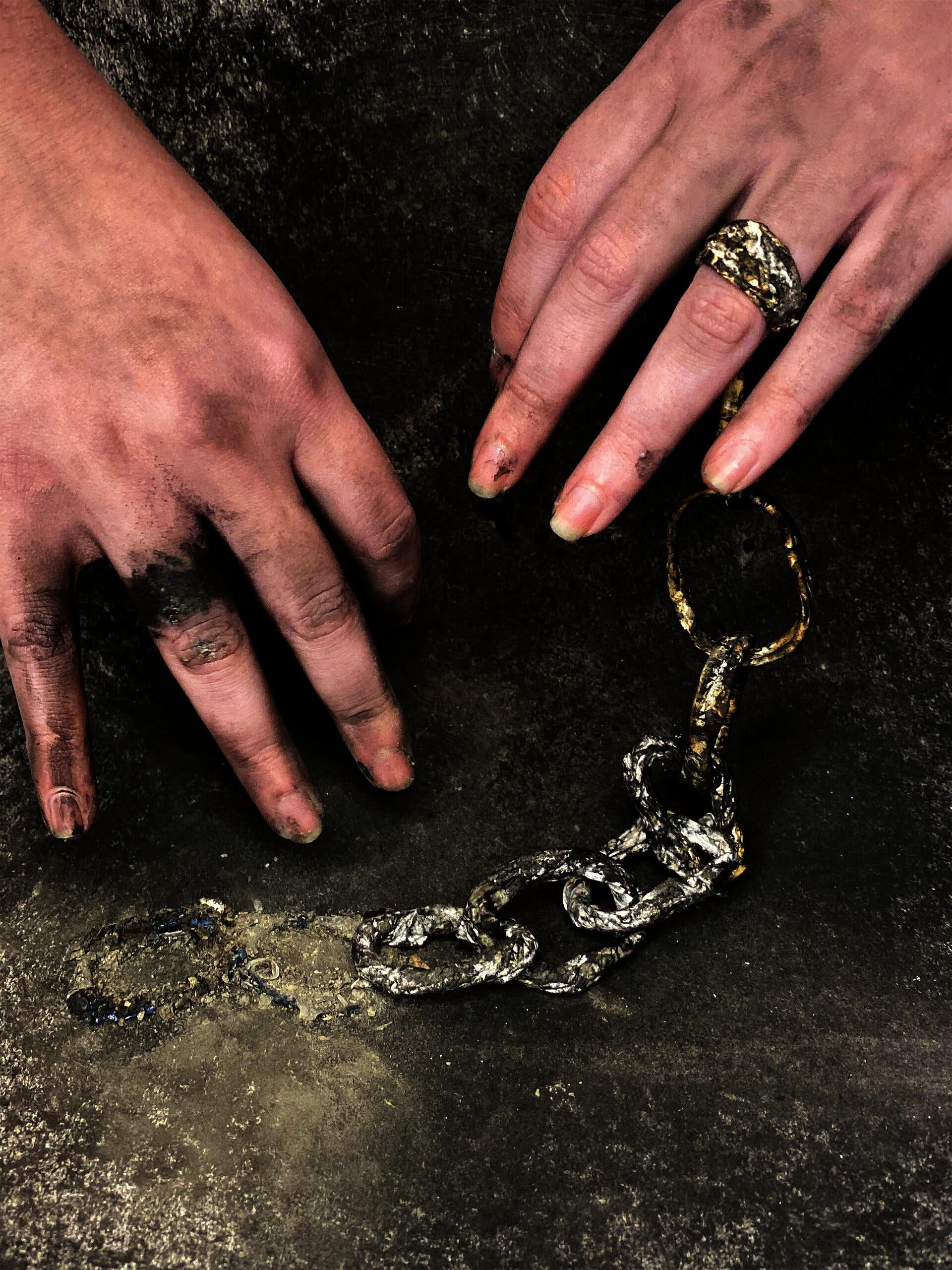 Hands with a chain and charcoal