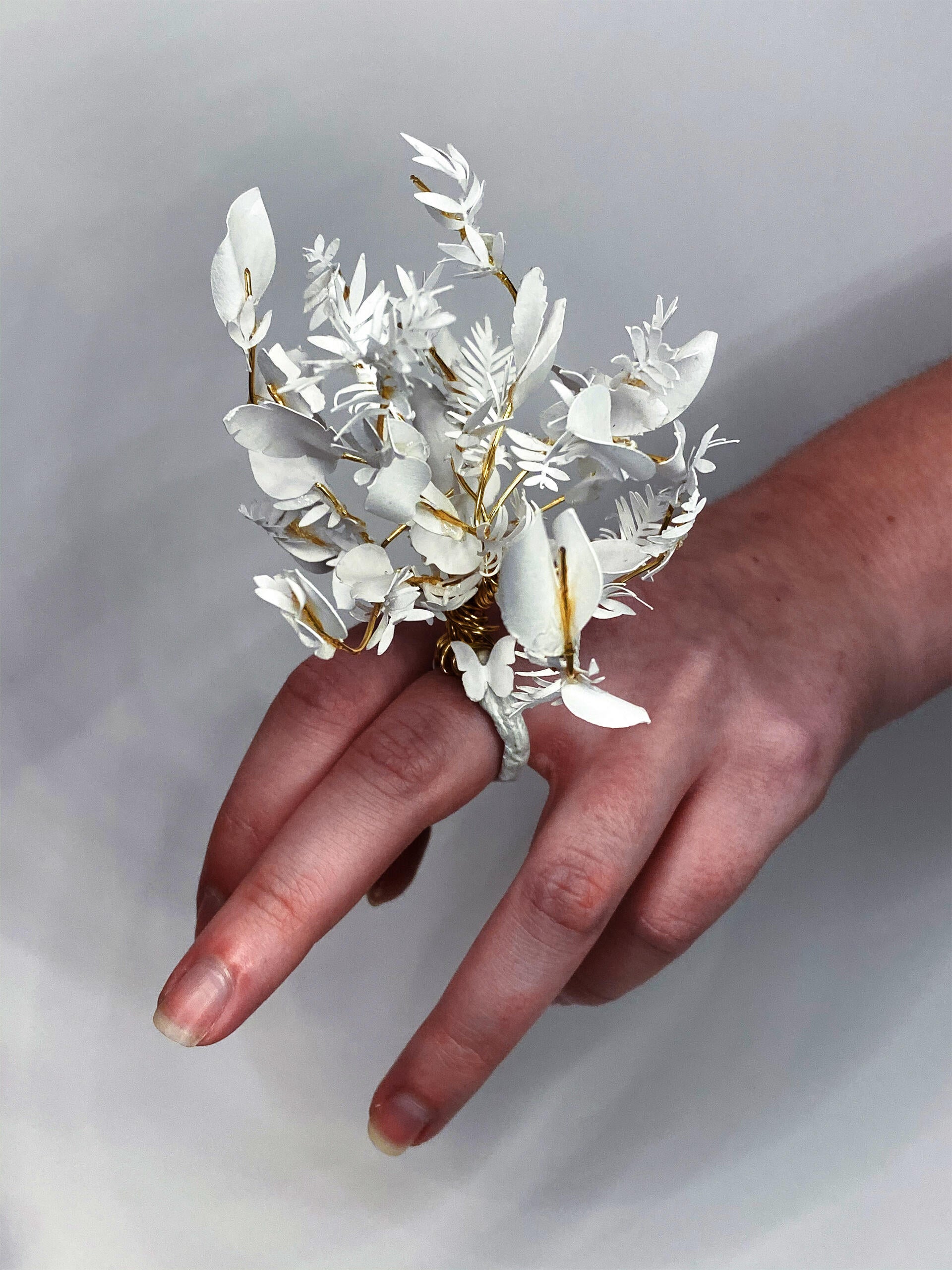 Hand with a sculptural floral ring made of paper and wire