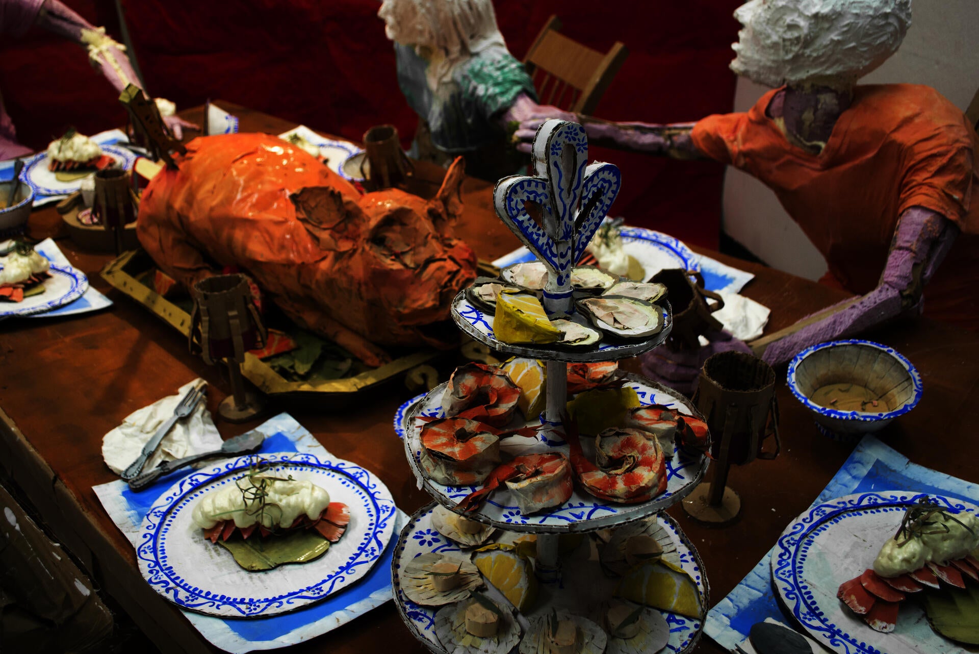 Installation sculpture of a group of people sitting around a dinner table.
