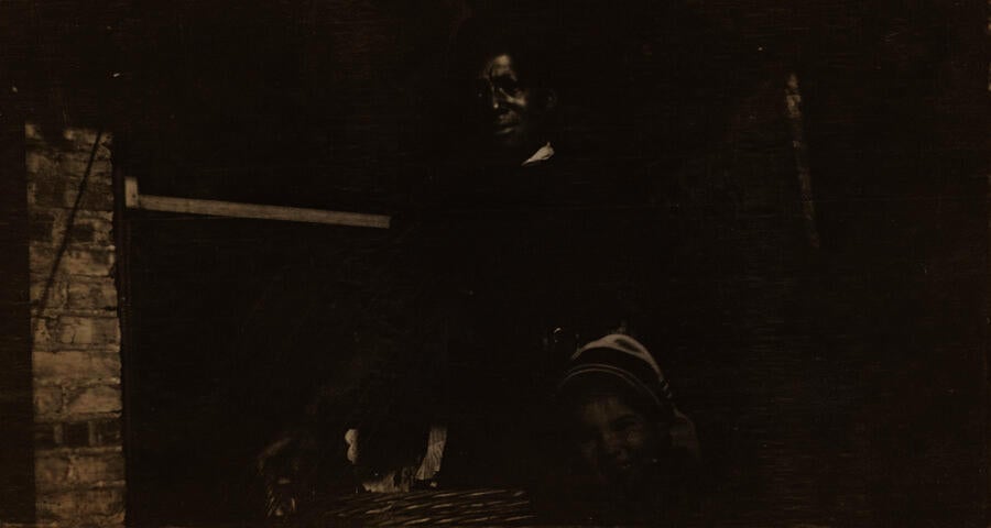 Black & white photograph of a black man standing with a child
