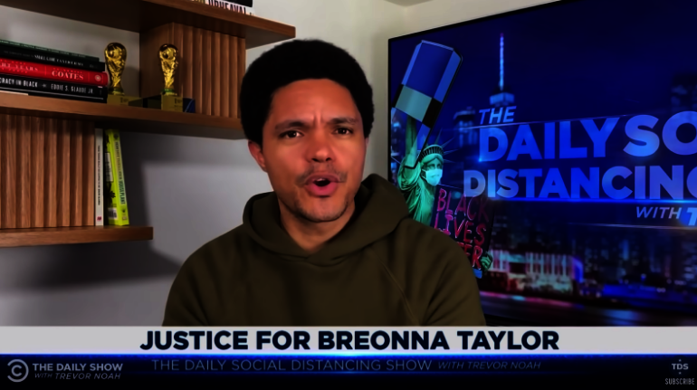 Trevor Noah speaking on set of the Daily Show, social distancing version