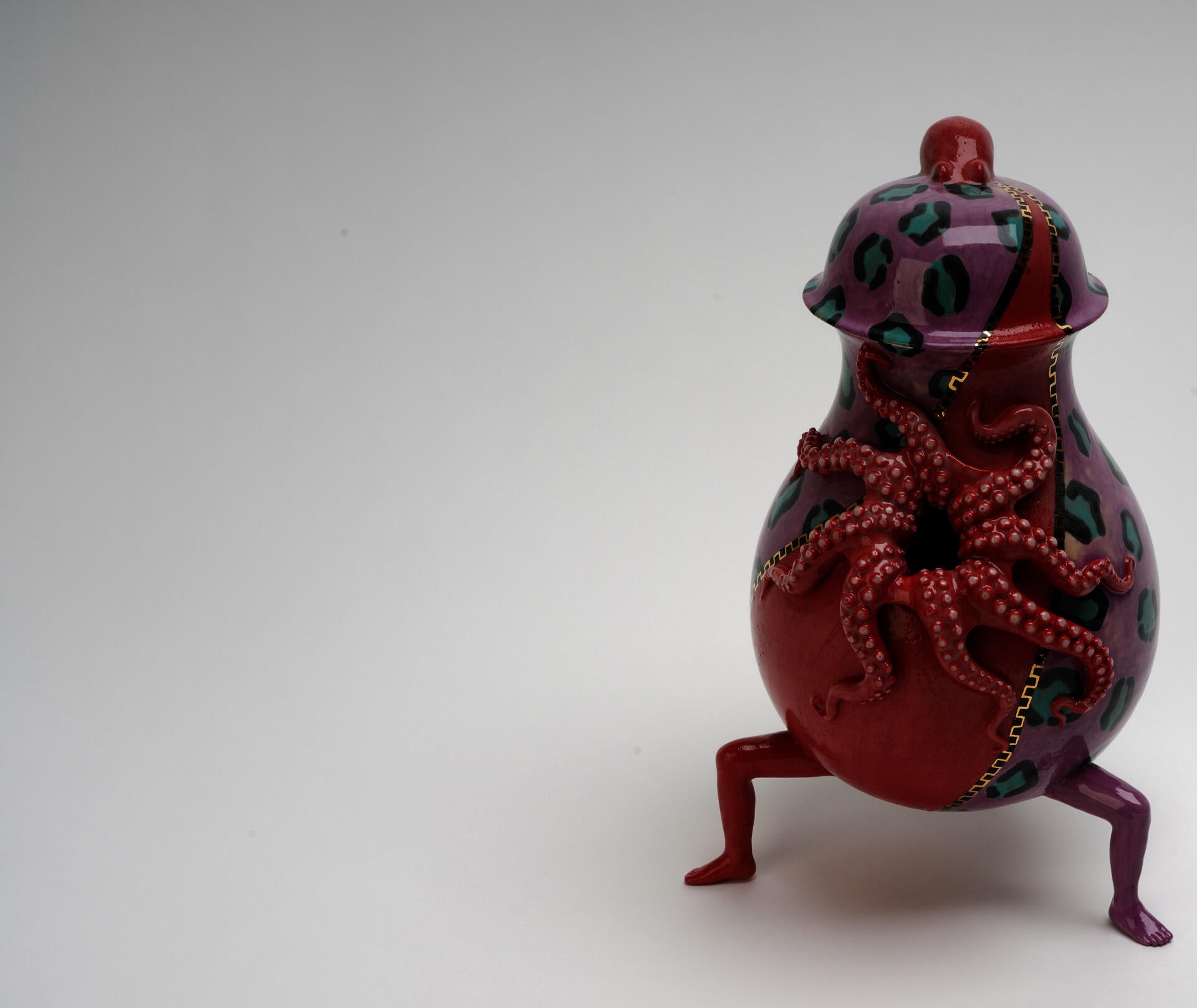 A vase features limbs, red octopus, luster zip and violet leopard print