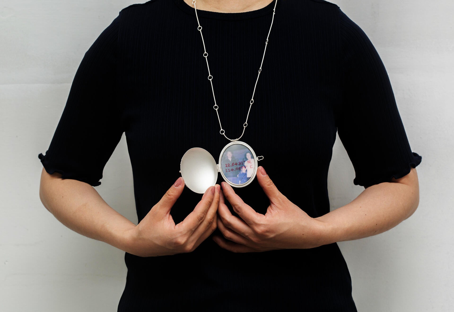 22.5431° N, 114.0579° E on the body, open locket view