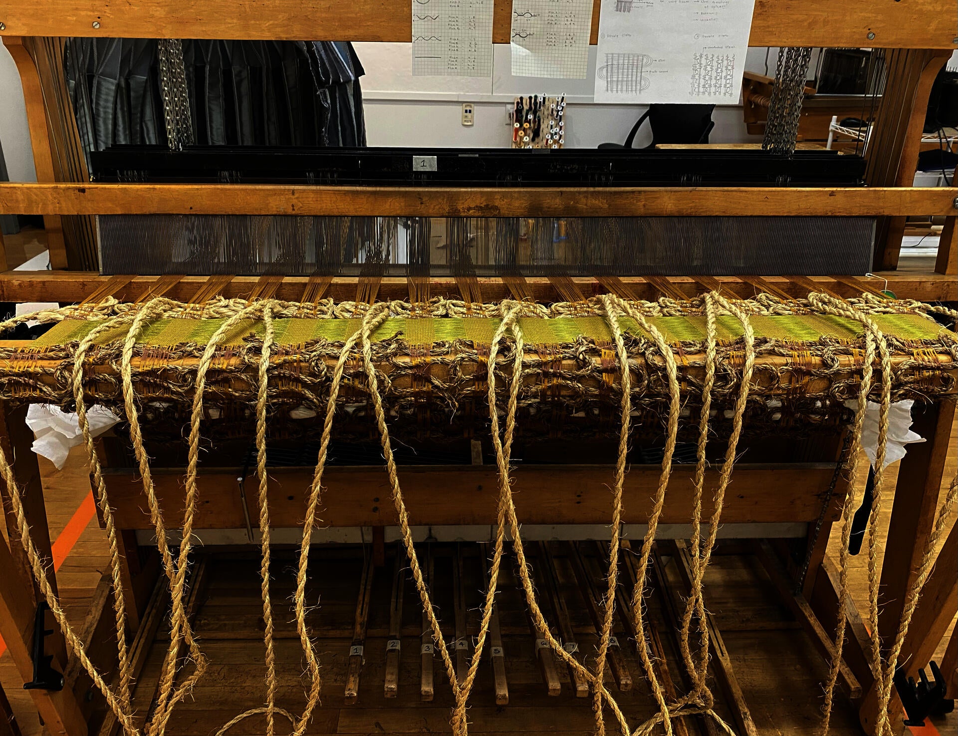 Image of the loom with handwoven piece on it