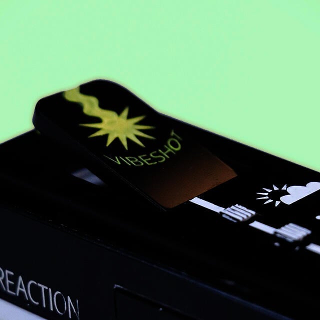 Closeup of the Vibelist feature: the vibeshot button is shown protruding from the surface