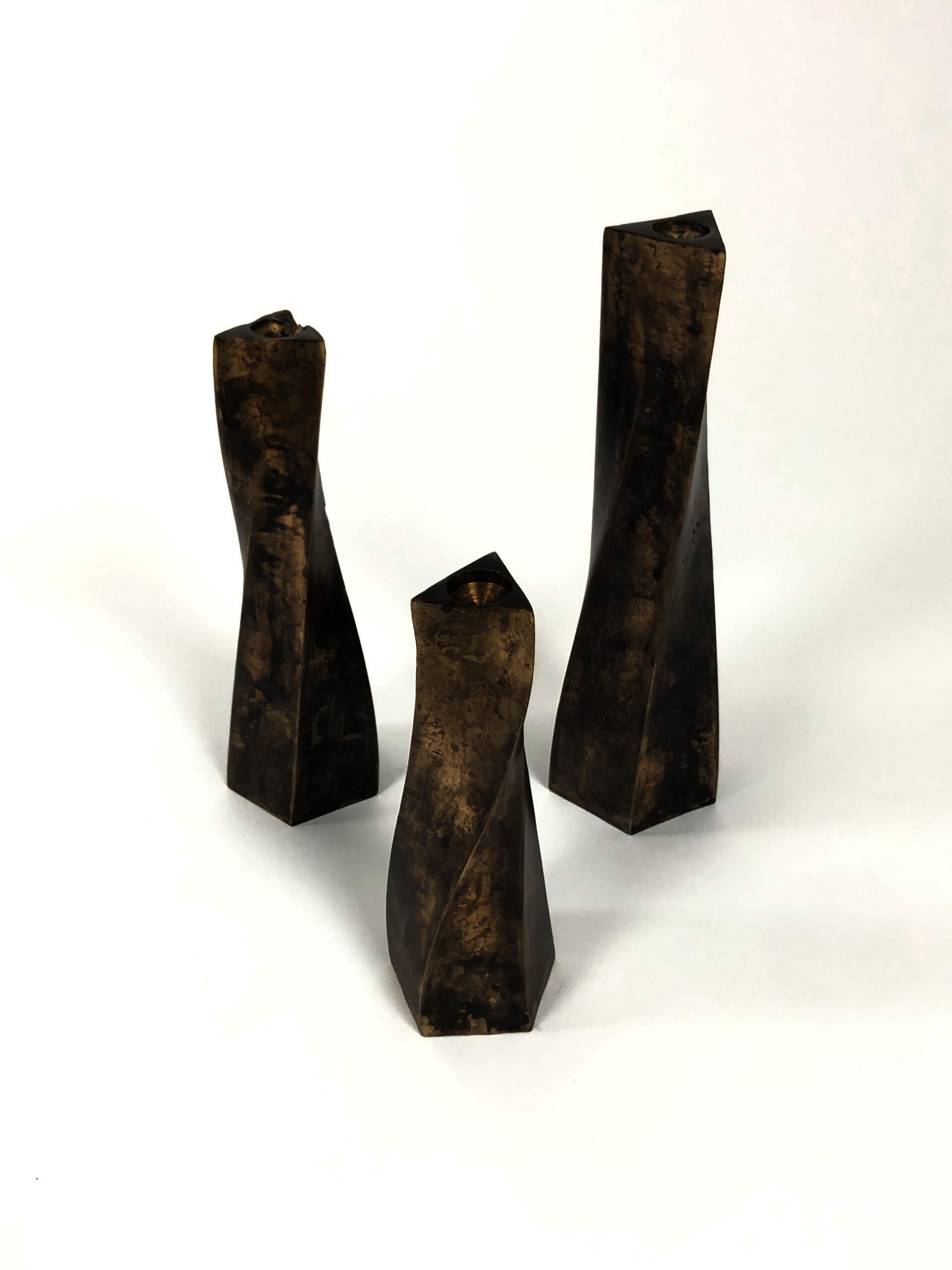 three bronze candle stick holders