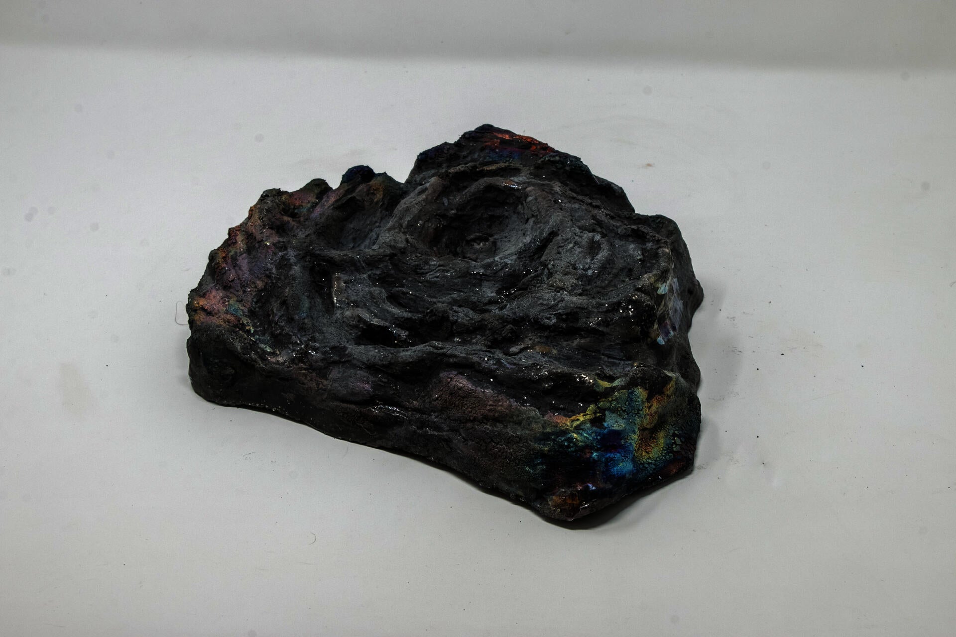 Ceramic cow patty with iridescent finish.