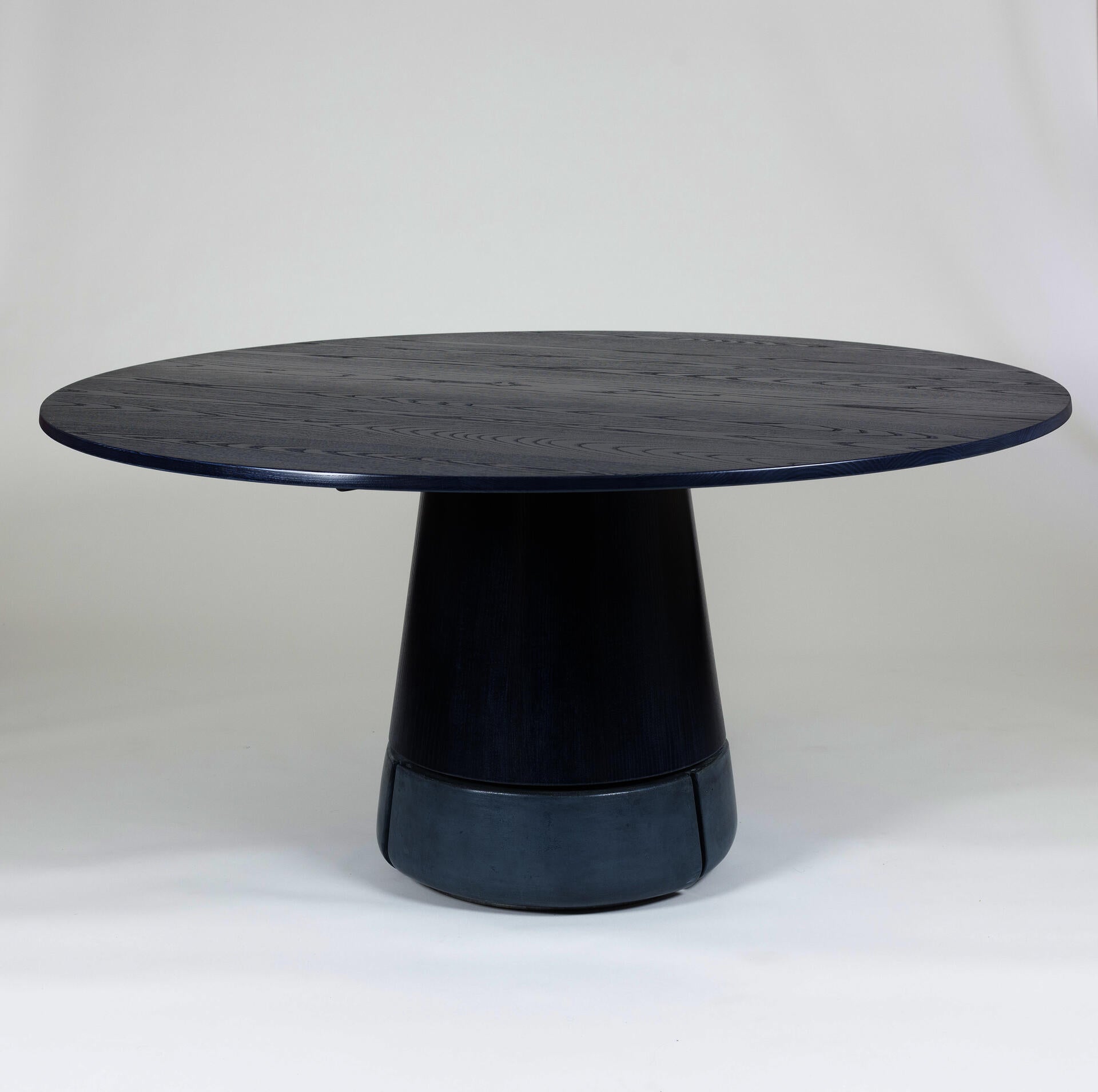 Blue round dining table with concrete base.