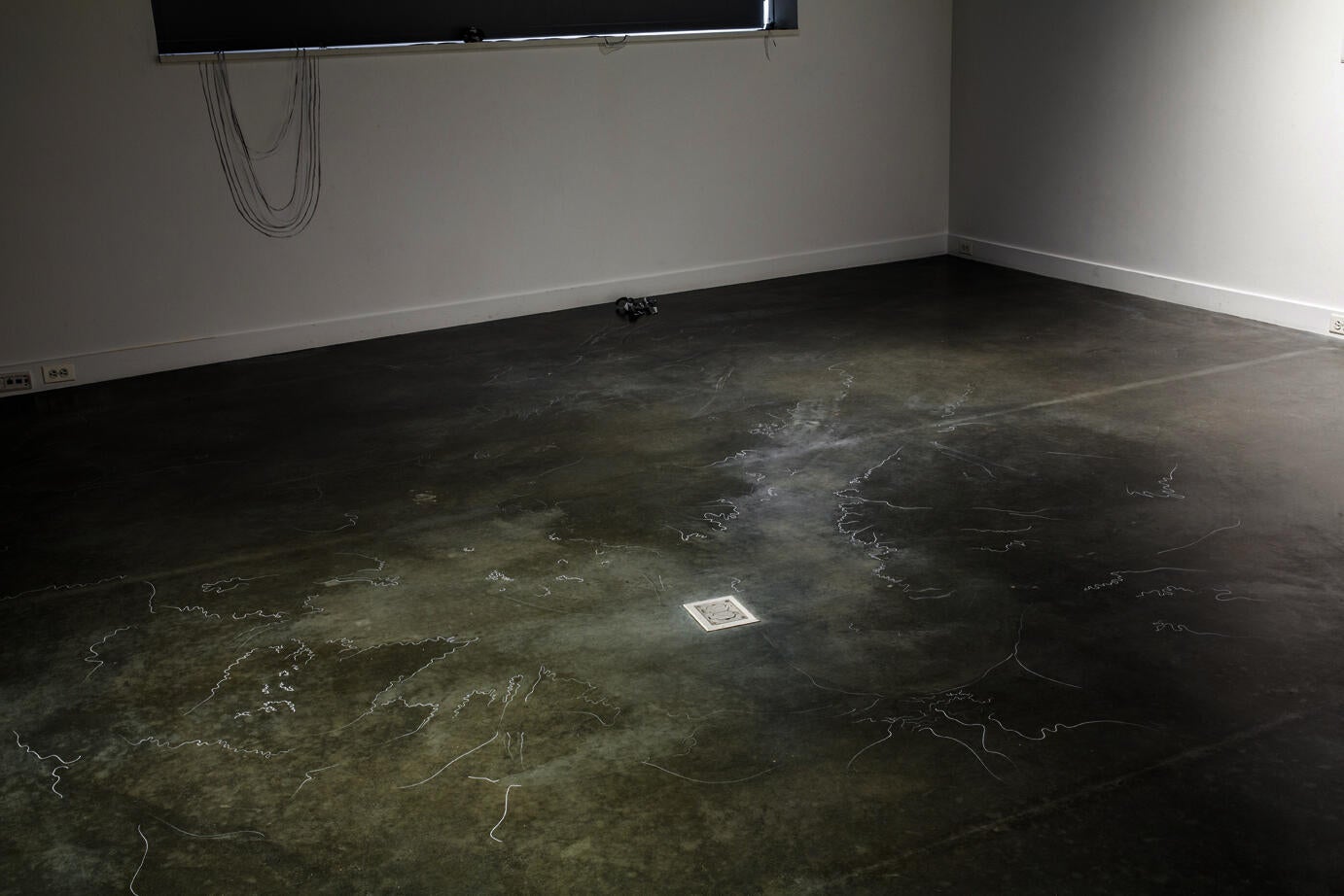 concrete gallery floor with thin white lines, as if salt water dried on the floor