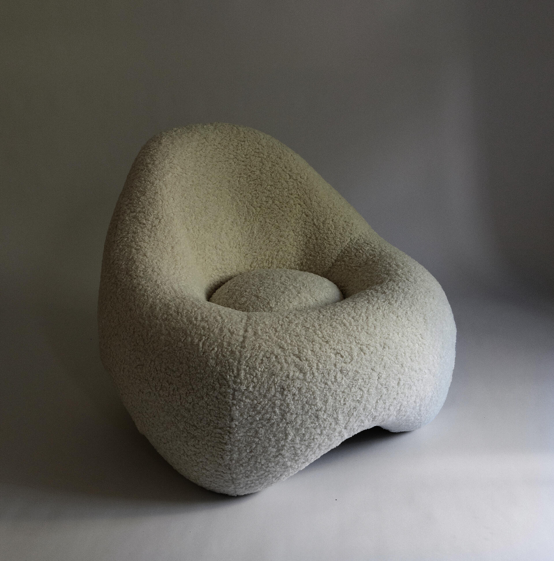 a soft, frame-less shape low lounge chair upholstered in sherpa