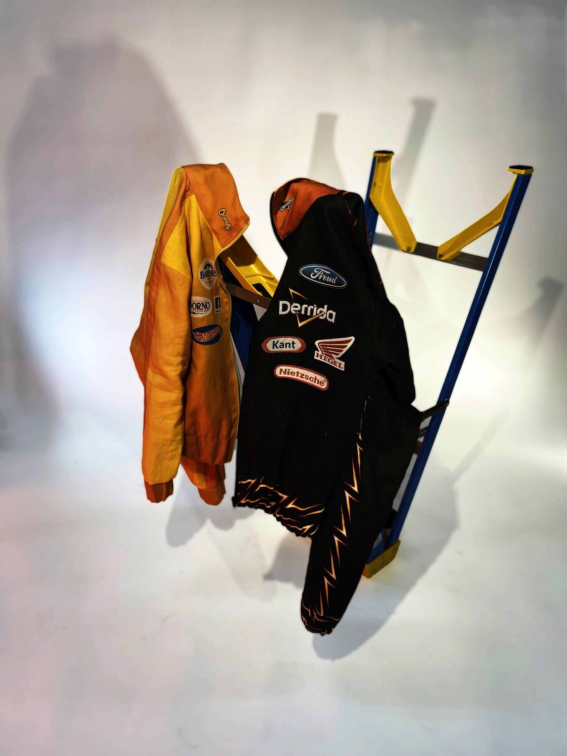 Two NASCAR style jackets with logos edited to replace brand names with theorist's names.