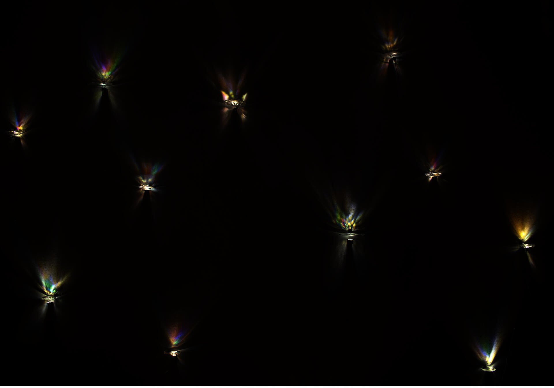 The color projections of the tension within the clear glass appear on the wall.