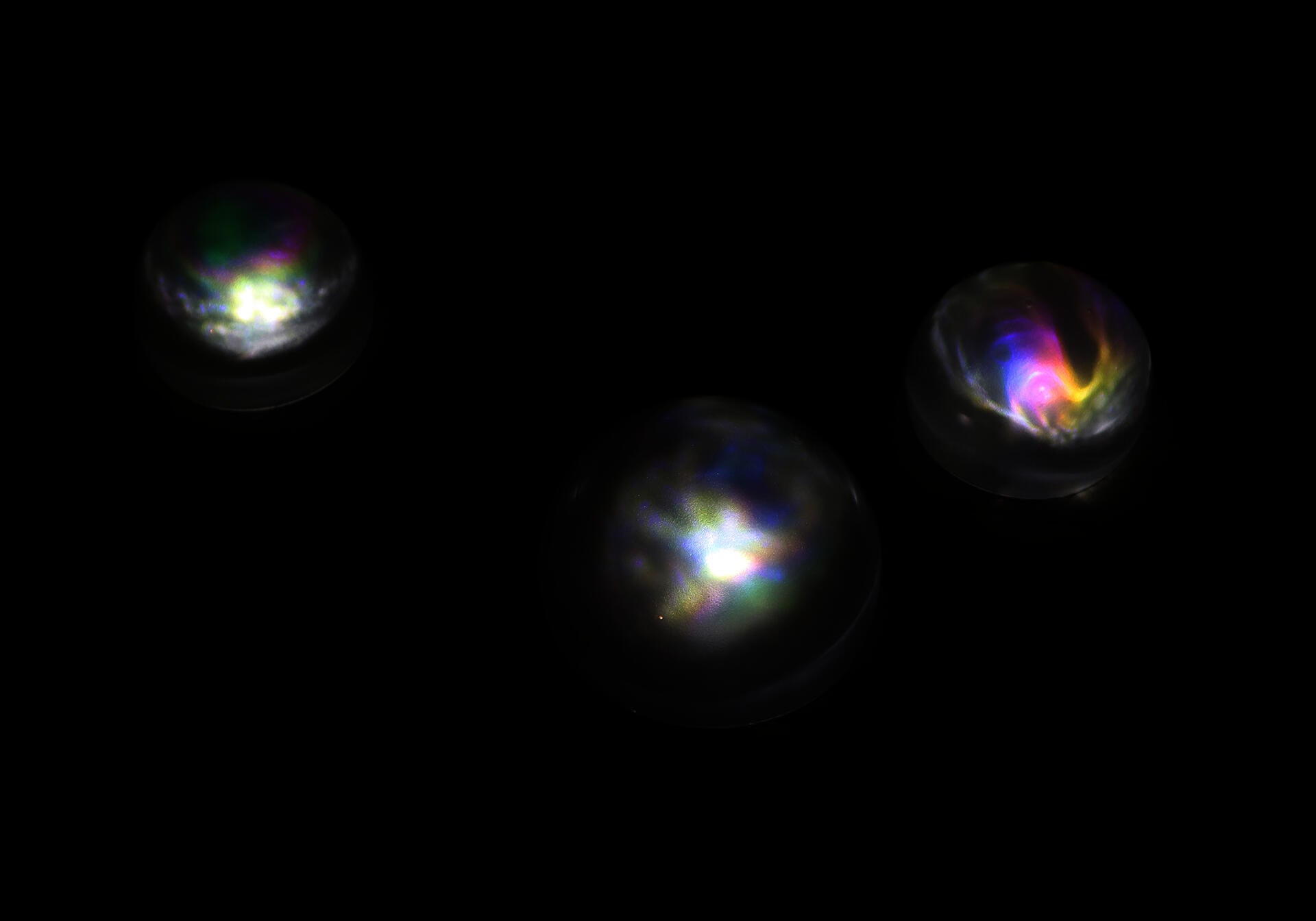 The outer glass hemispheres hold the projections of stressed glass pieces expressing its stress as various colors and textures.